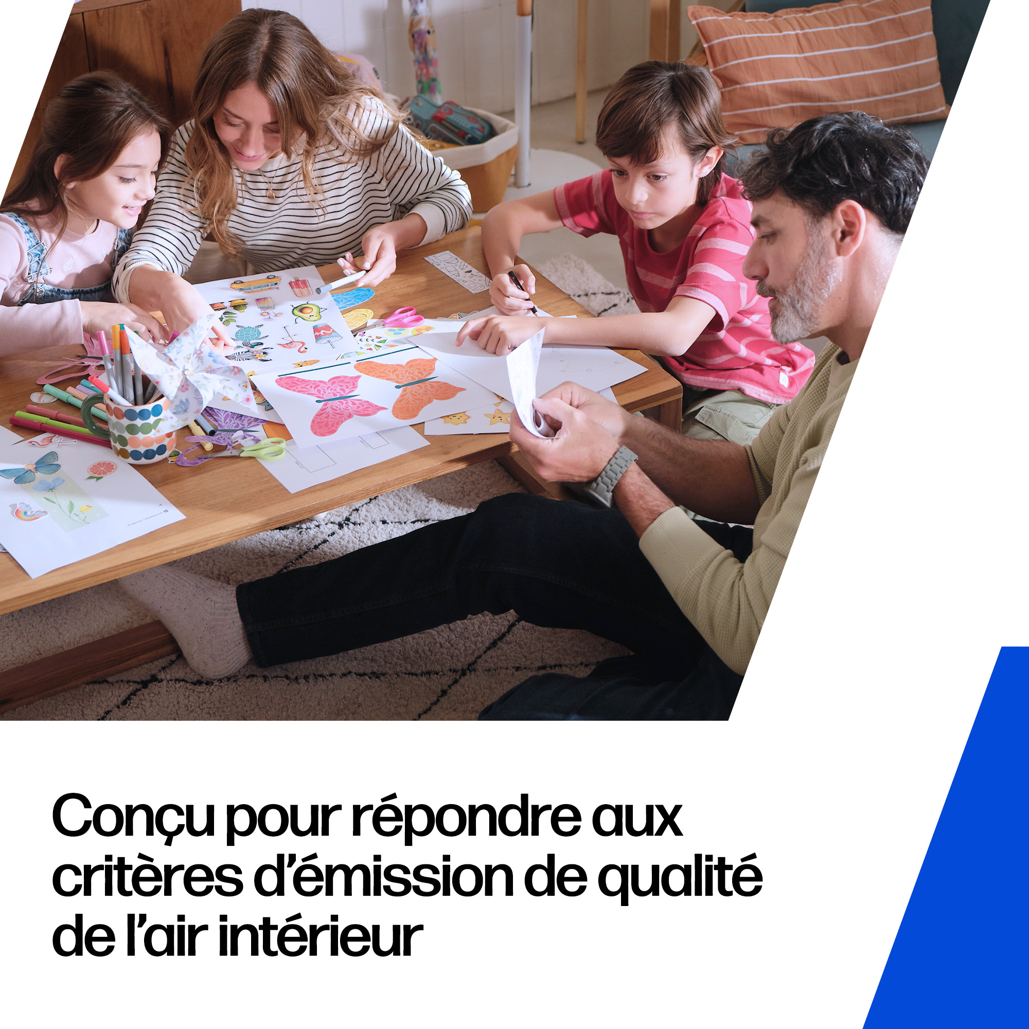 Famille faisant du bricolage sur une table en bois. Maman, Papa et deux enfants colorent et découpent du papier.