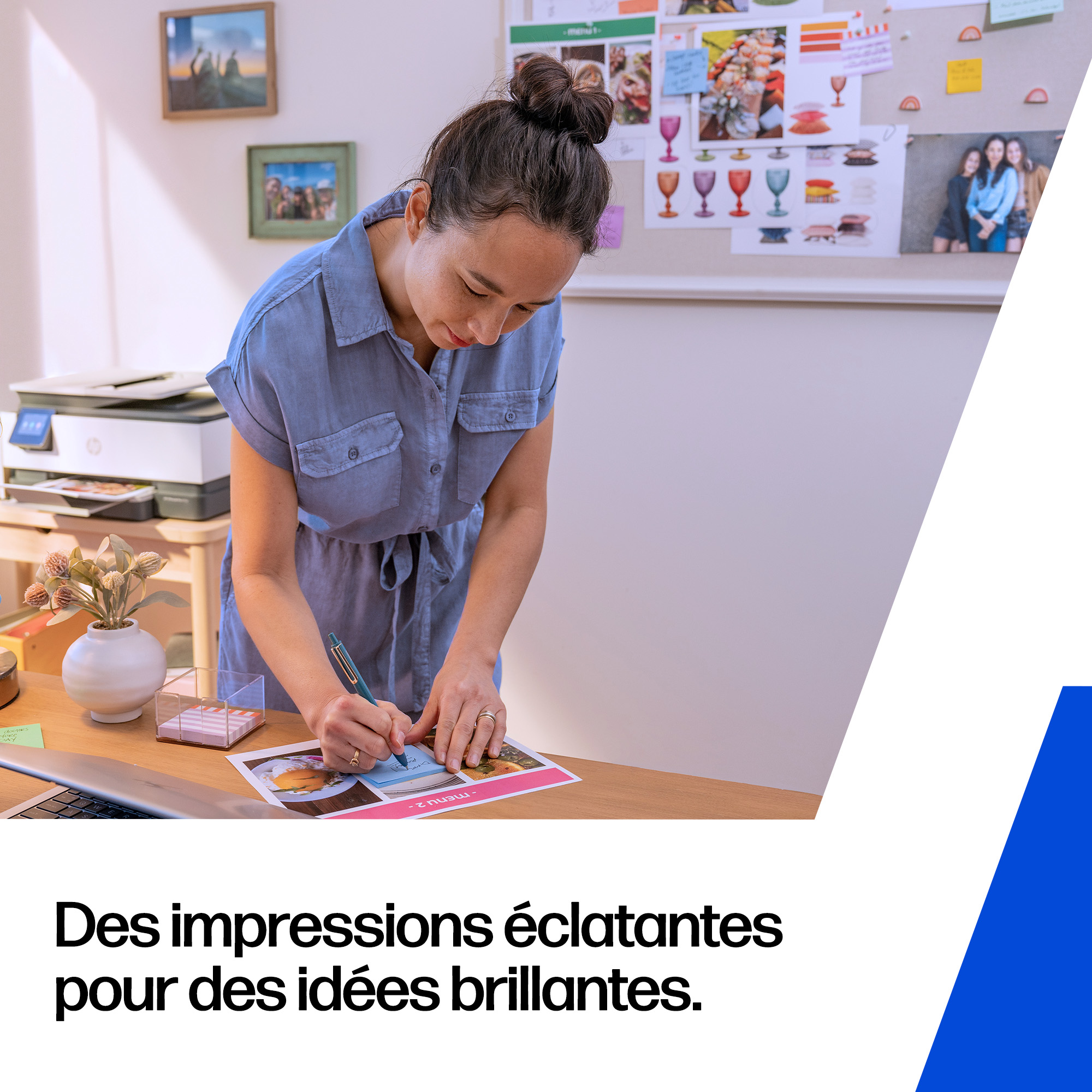 Une femme en robe bleue écrit sur une impression. Une imprimante est à proximité.