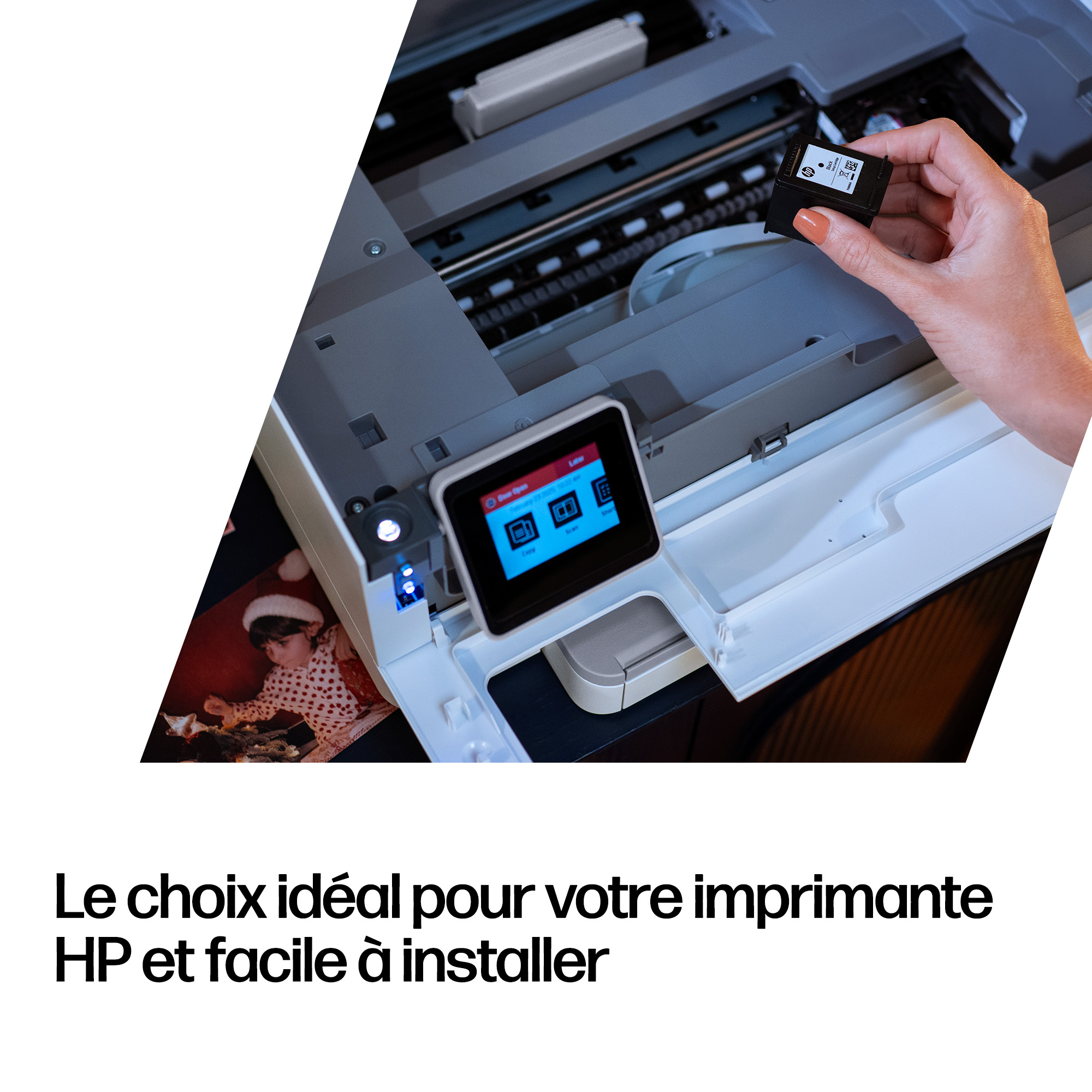 Une main tient une cartouche d'encre noire sur une imprimante avec une photo d'enfant.