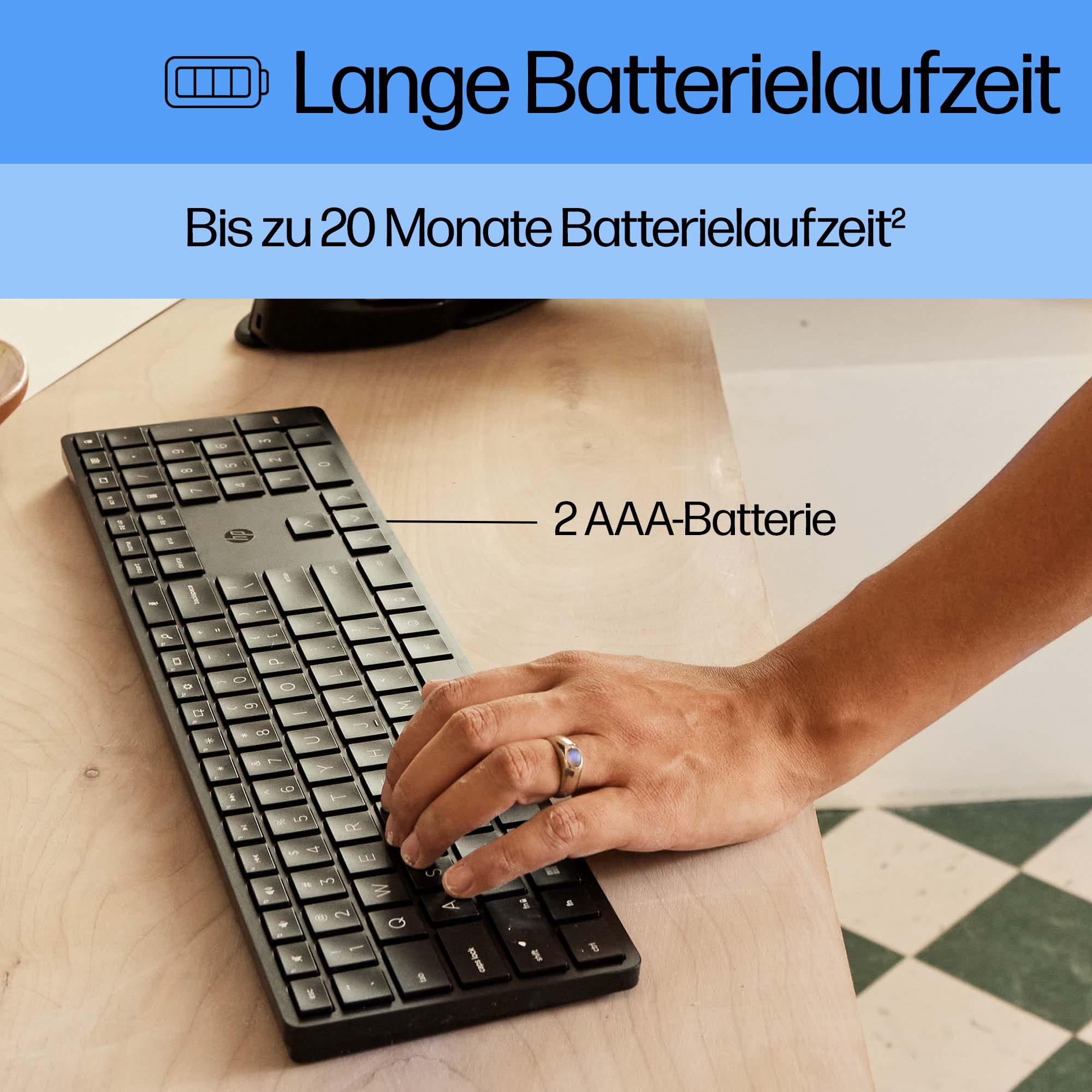 Eine Person benutzt eine schwarze Tastatur mit der Aufschrift '2 AAA-Batterie'.