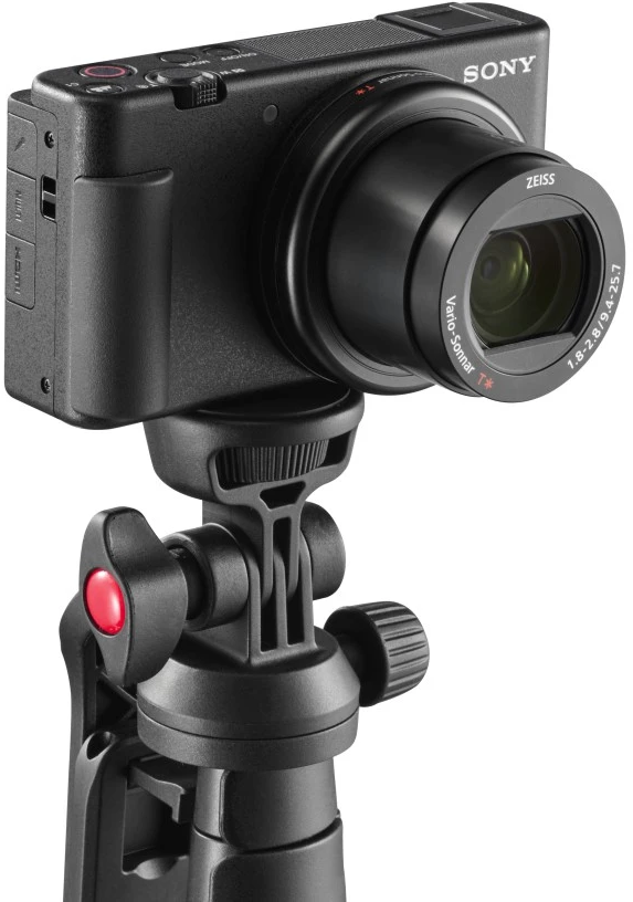 Una fotocamera Sony nera con obiettivo è montata su un treppiede nero.