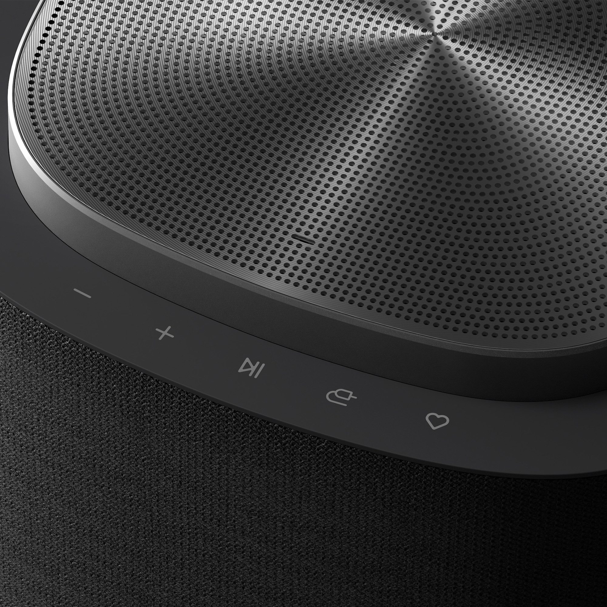 Primer plano de un altavoz negro con panel de control y patrón perforado.