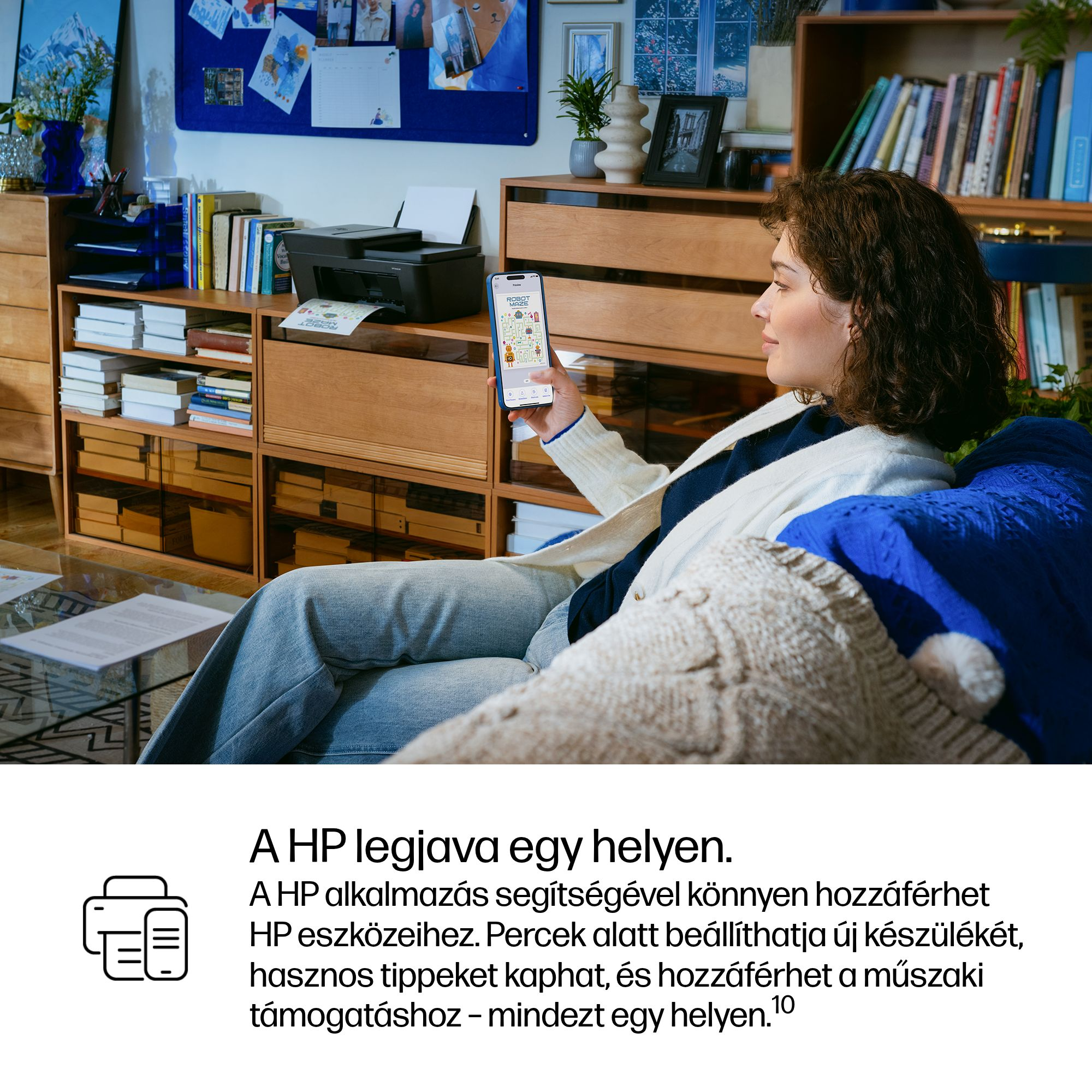 Egy nő ül a kanapén, és egy okostelefont tart, amely egy nyomtatót jelenít meg.