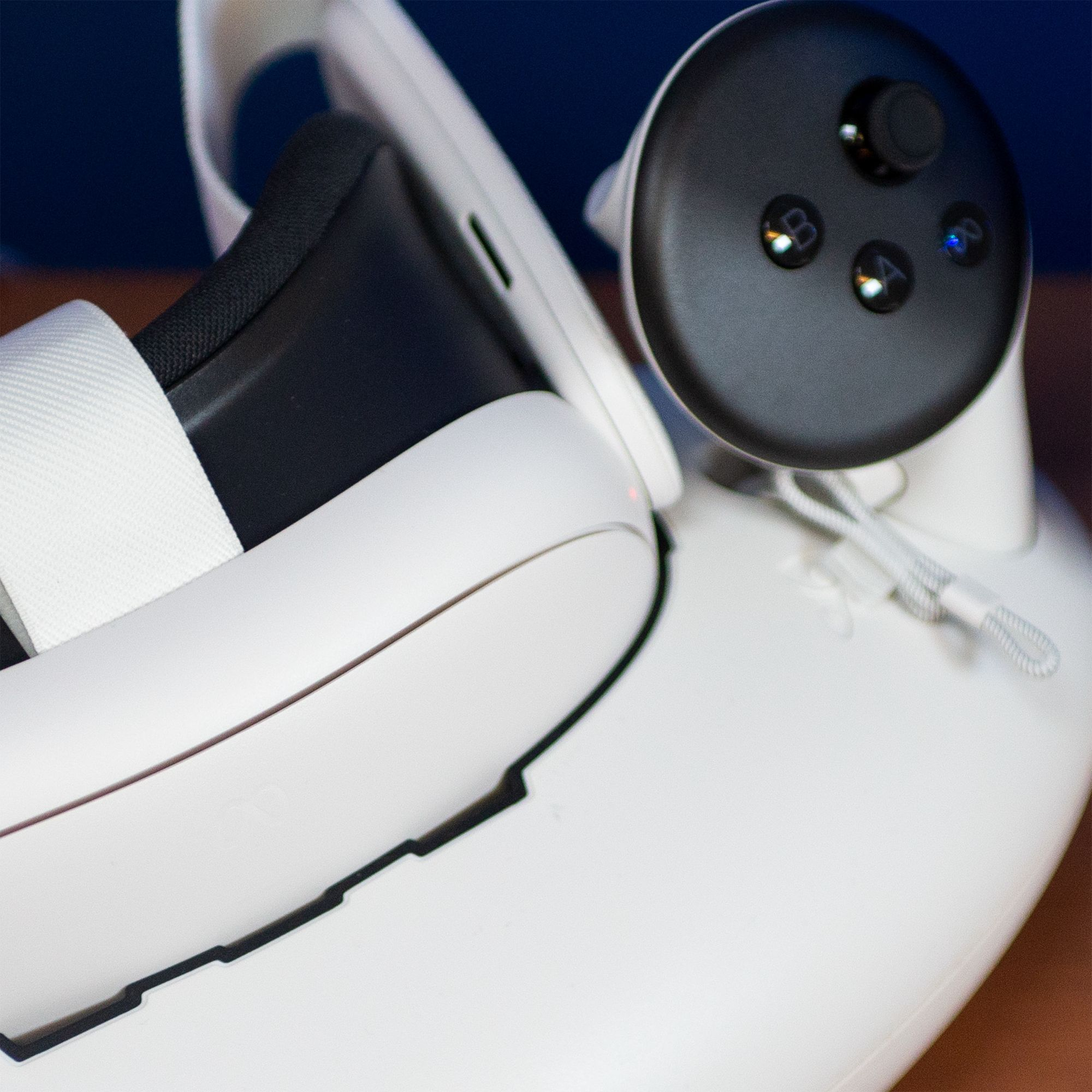 Weiße VR-Brille mit schwarzem Controller auf Ladestation.