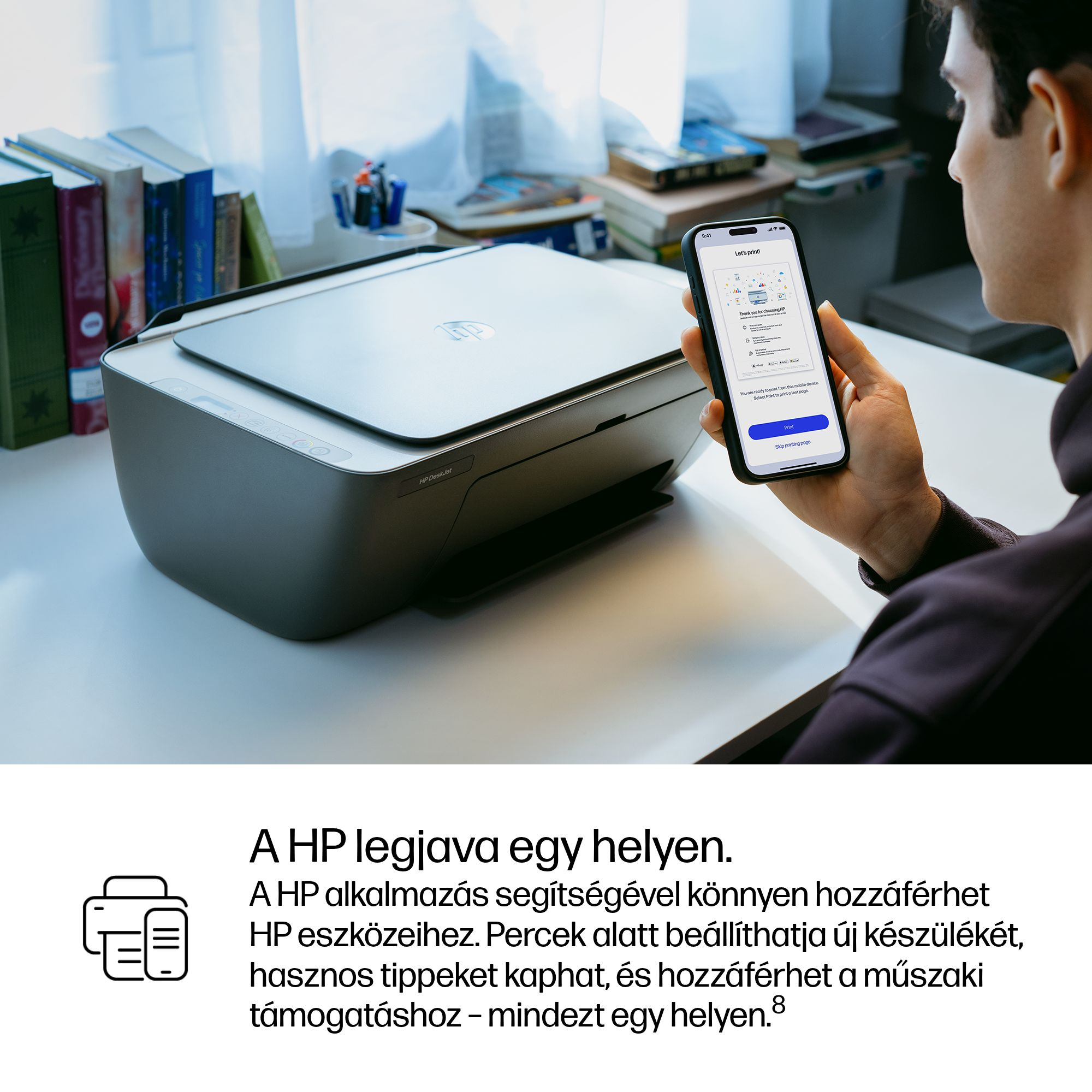 Férfi HP nyomtatót használ okostelefonnal. Könyvek és tollak hátul.