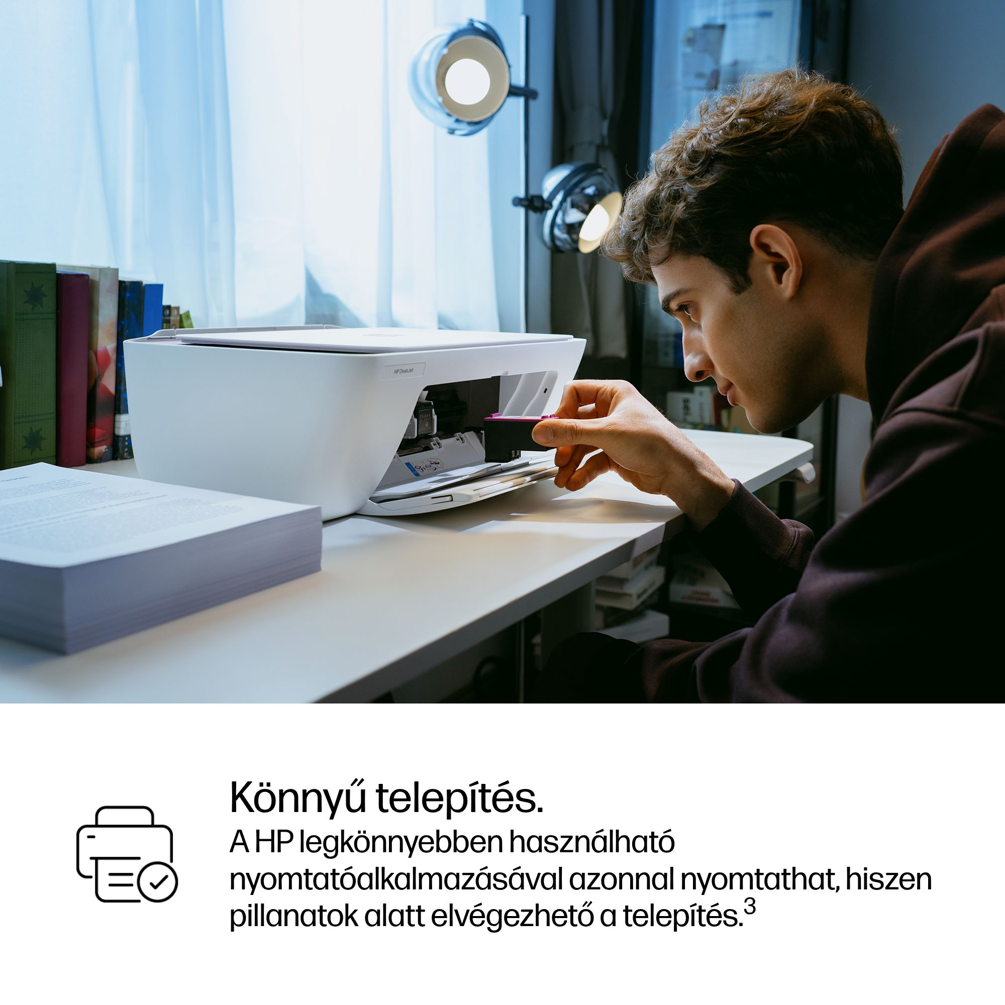 Férfi festékkazettát helyez be egy fehér HP nyomtatóba.