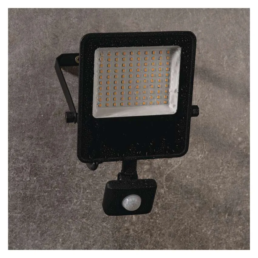 Fekete LED-es reflektor mozgásérzékelővel szürke falon.