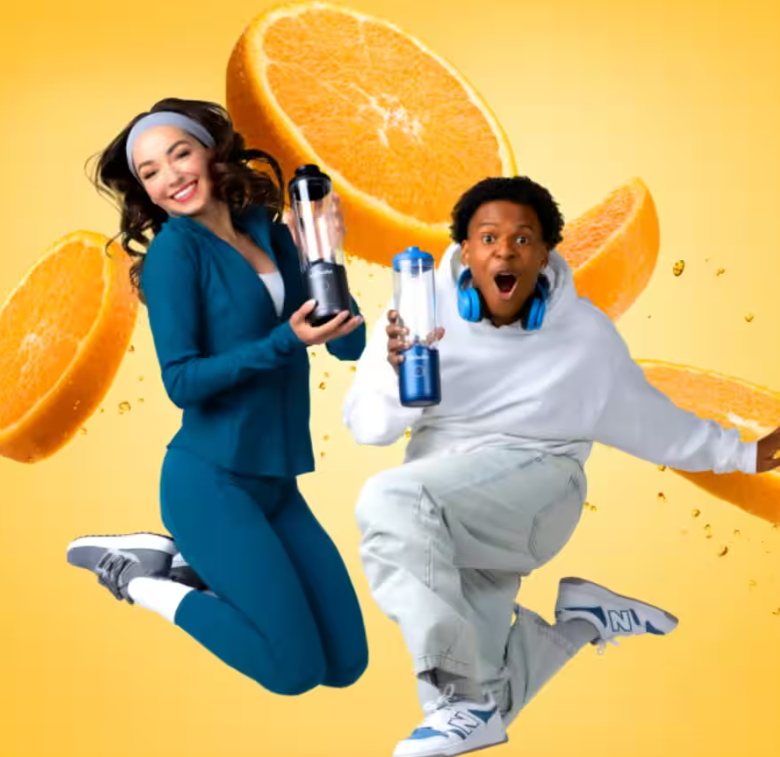 Dwie osoby skaczą z pomarańczami i blenderami na żółtym tle.