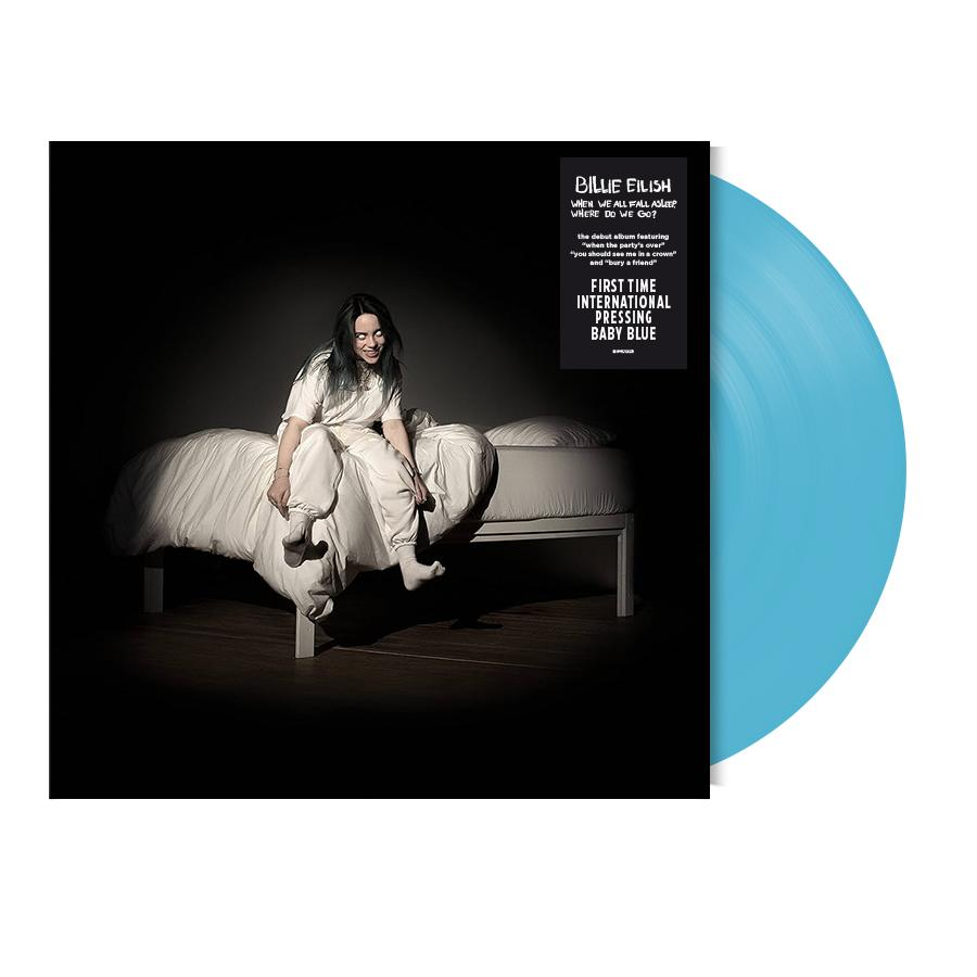 Billie Eilish sitzt auf einem Bett mit einer babyblauen Schallplatte für "When We All Fall Asleep".