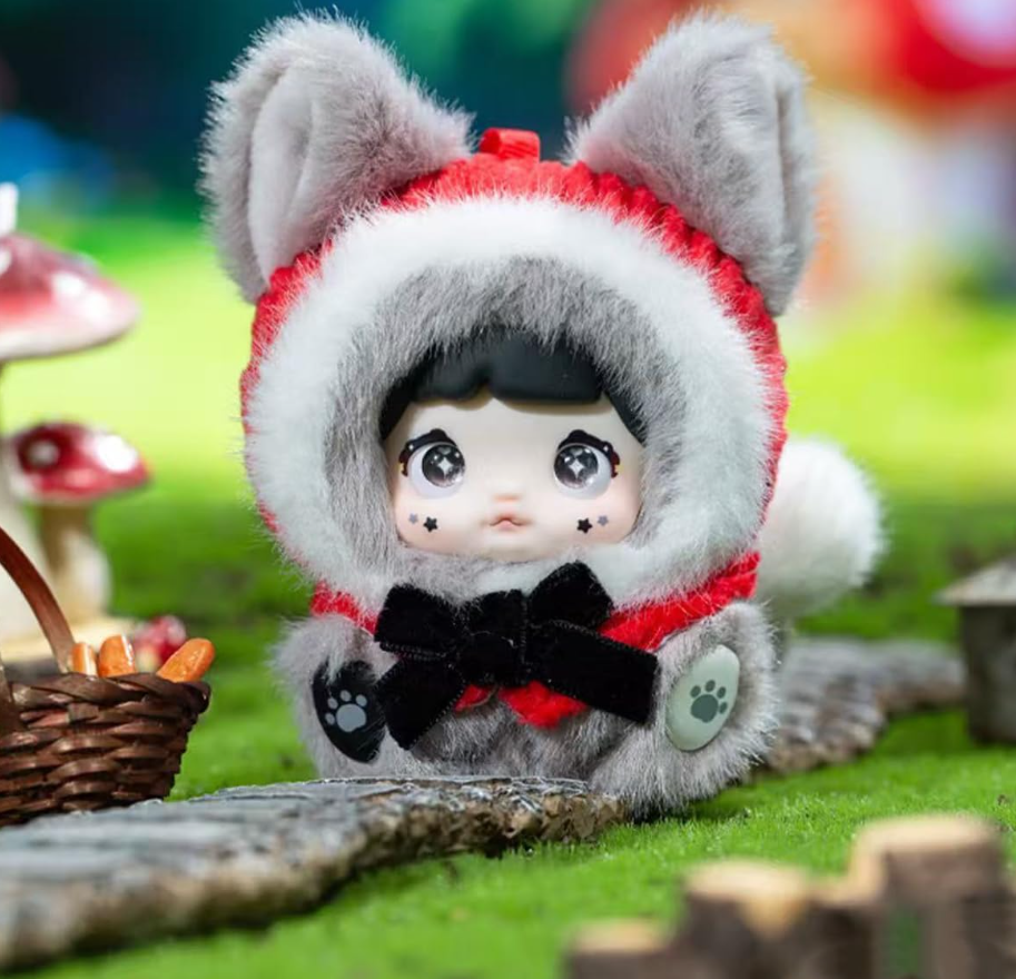 Eine Puppe in einem flauschigen Wolfskostüm mit Kapuze und schwarzer Schleife.