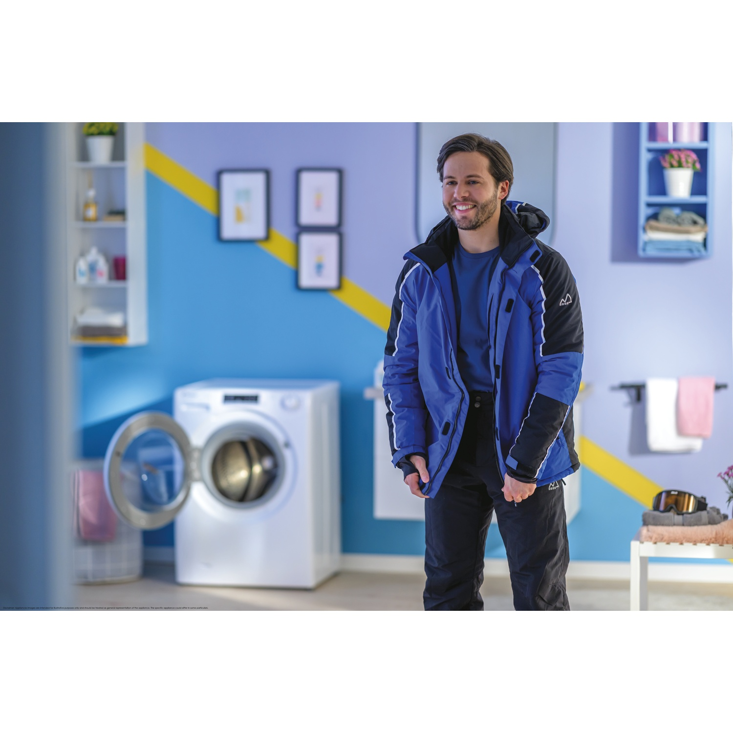 Uomo in giacca blu e pantaloni neri sorride davanti a lavatrice e scaffali.
