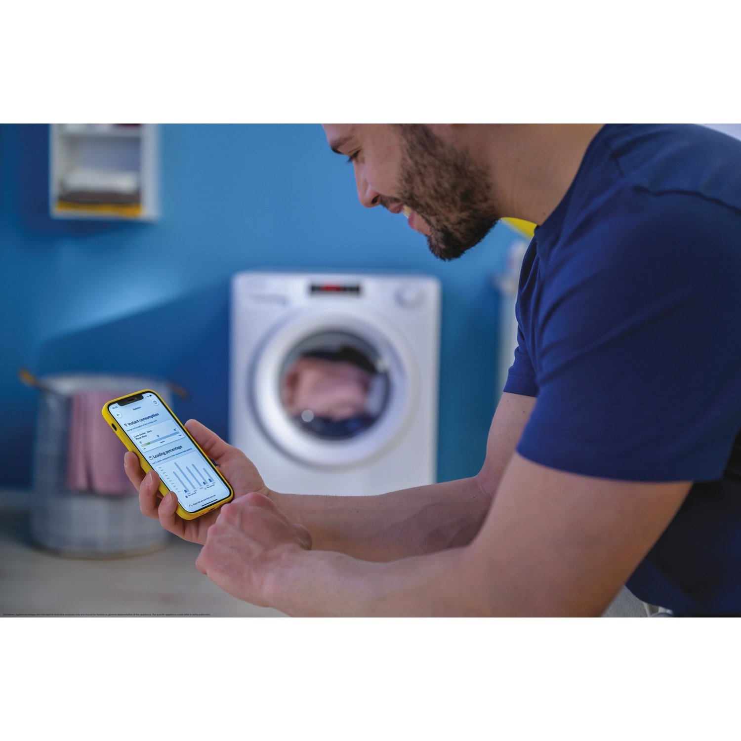 Uomo con smartphone davanti a lavatrice in stanza blu.
