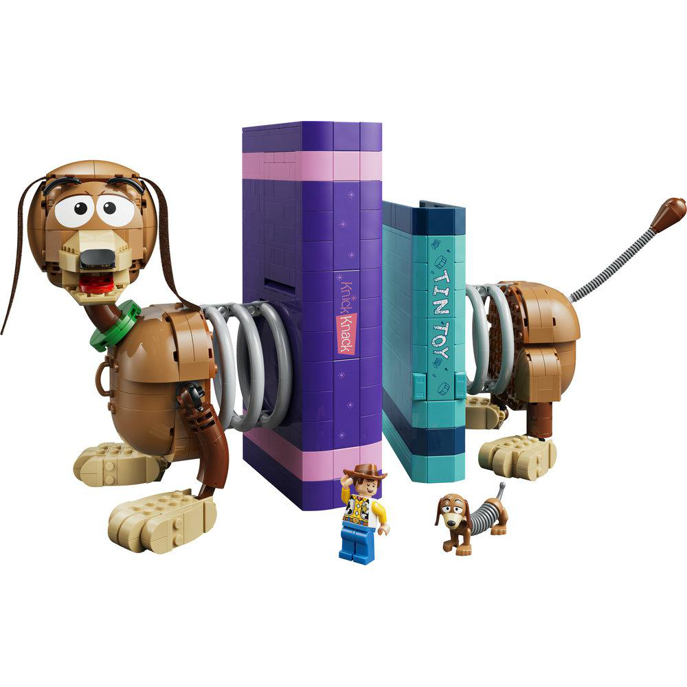 Spielzeugfiguren: Slinky Dog, Woody, zwei kleine Hunde, zwei Bücher.