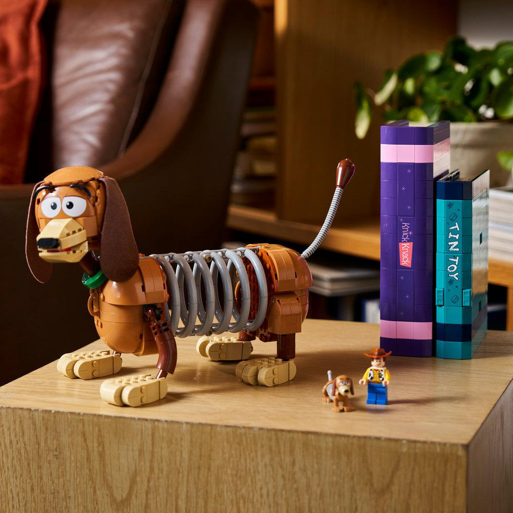 Ein Slinky-Hund-Spielzeug mit Woody und einem kleinen Hund neben Büchern.