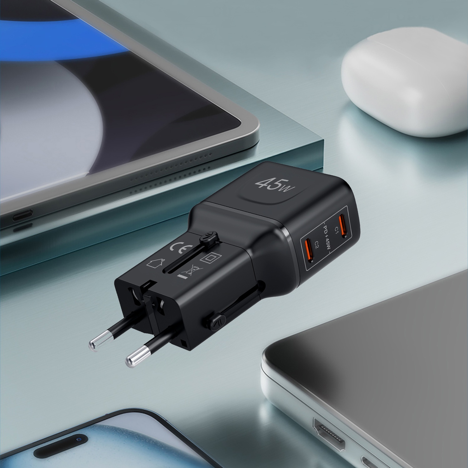 Adattatore da viaggio nero da 45W con porte USB-C, accanto a tablet e telefono.