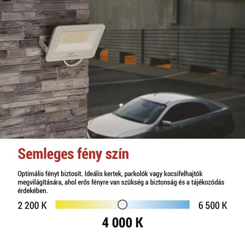 Egy fehér LED-es reflektor egy kőfalon parkolót és egy autót világít meg.