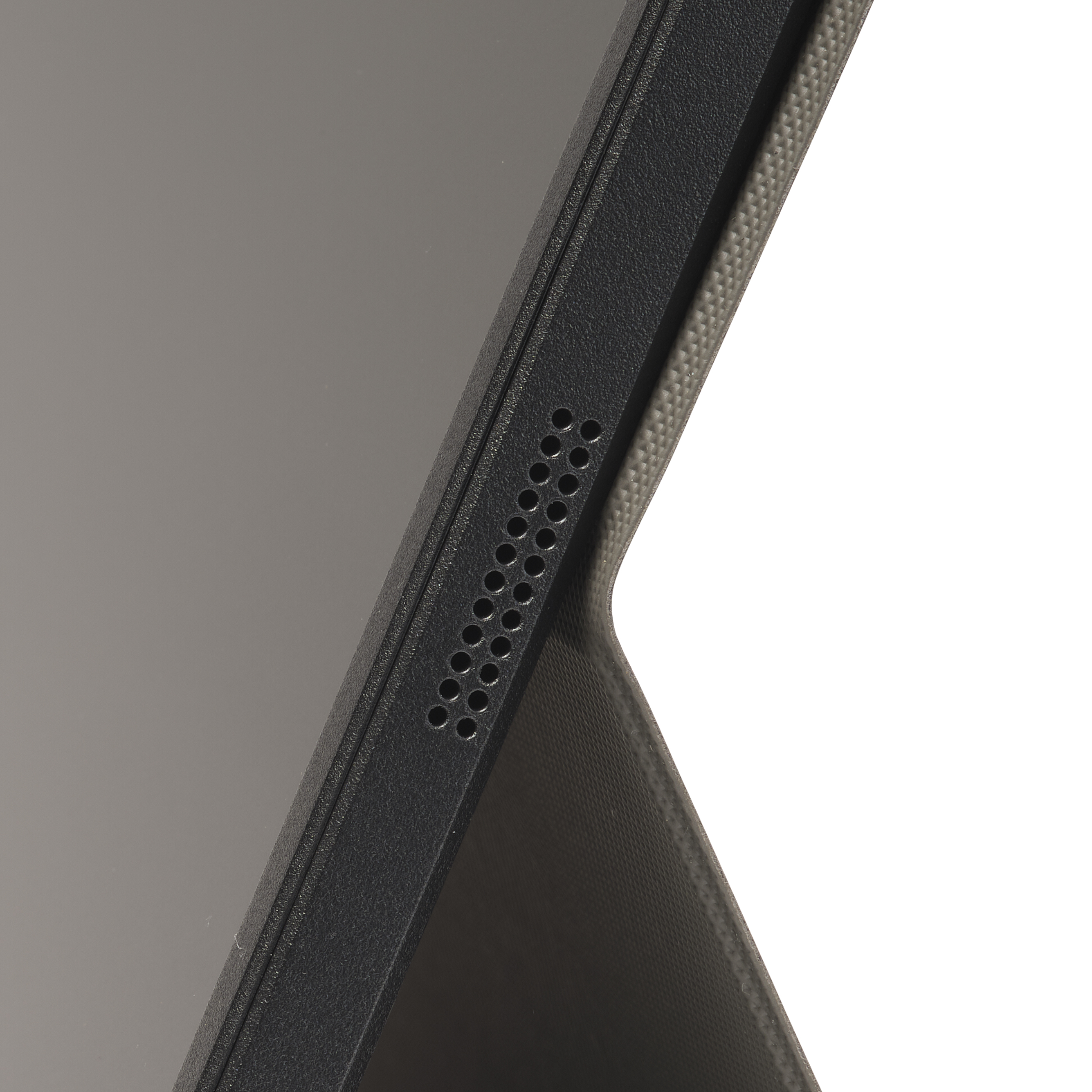 Detailaufnahme eines schwarzen Tablet-Gehäuses mit Lautsprecheröffnungen.