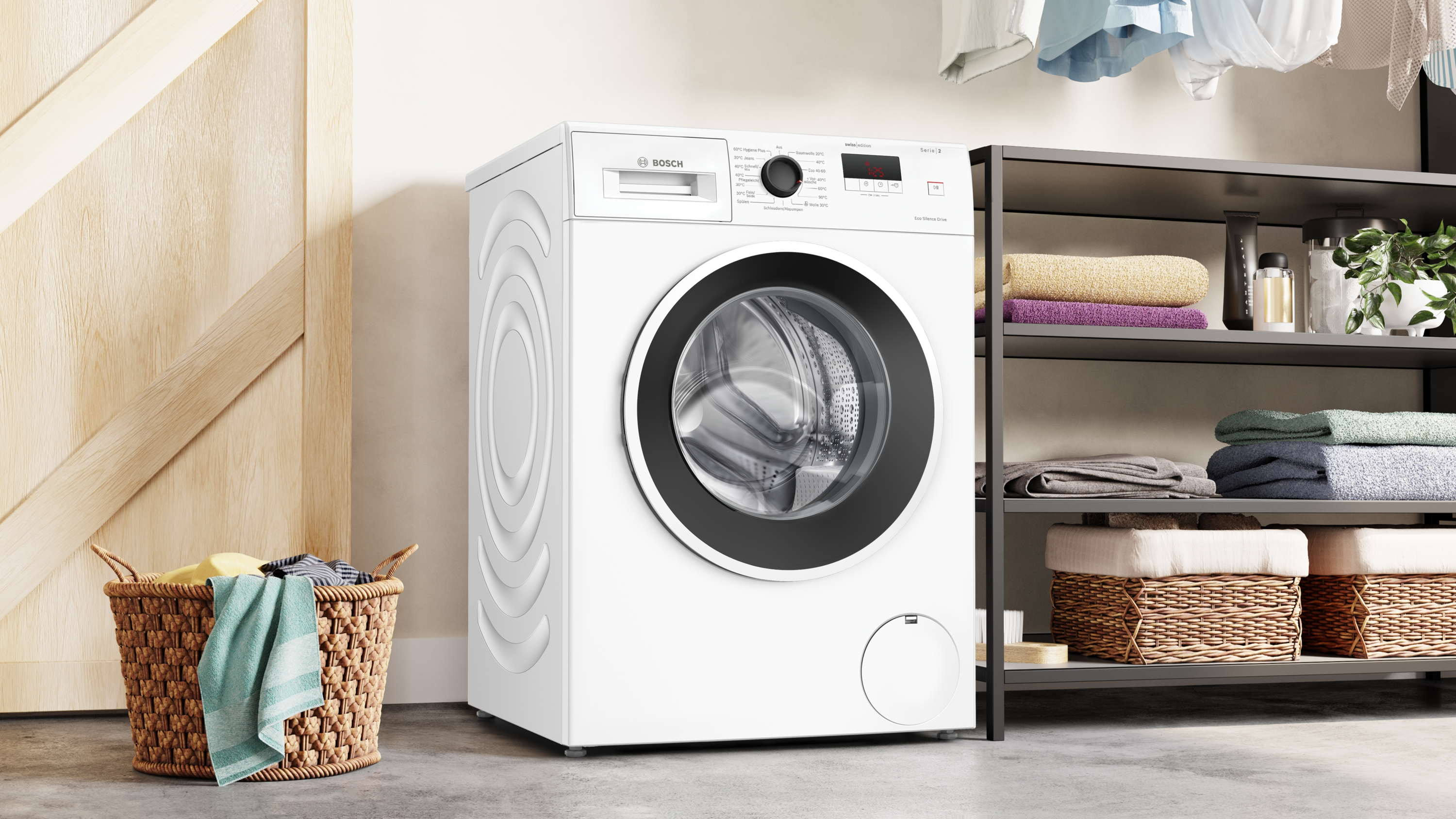 Eine weiße Bosch Waschmaschine steht neben einem Wäschekorb und einem Regal mit Handtüchern.