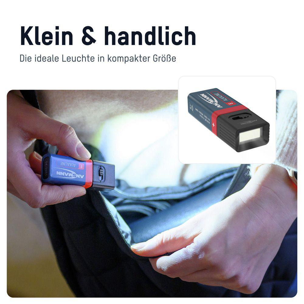 Eine Person hält eine kleine, blau-orange Taschenlampe in der Hand. Die Lampe leuchtet.