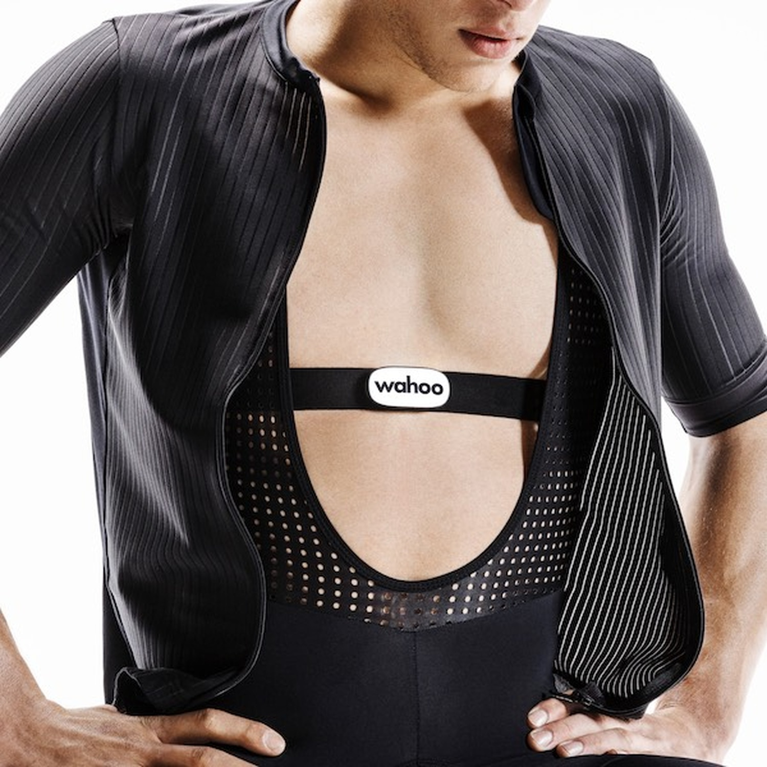 A man wears a black cycling jersey with a heart rate monitor.