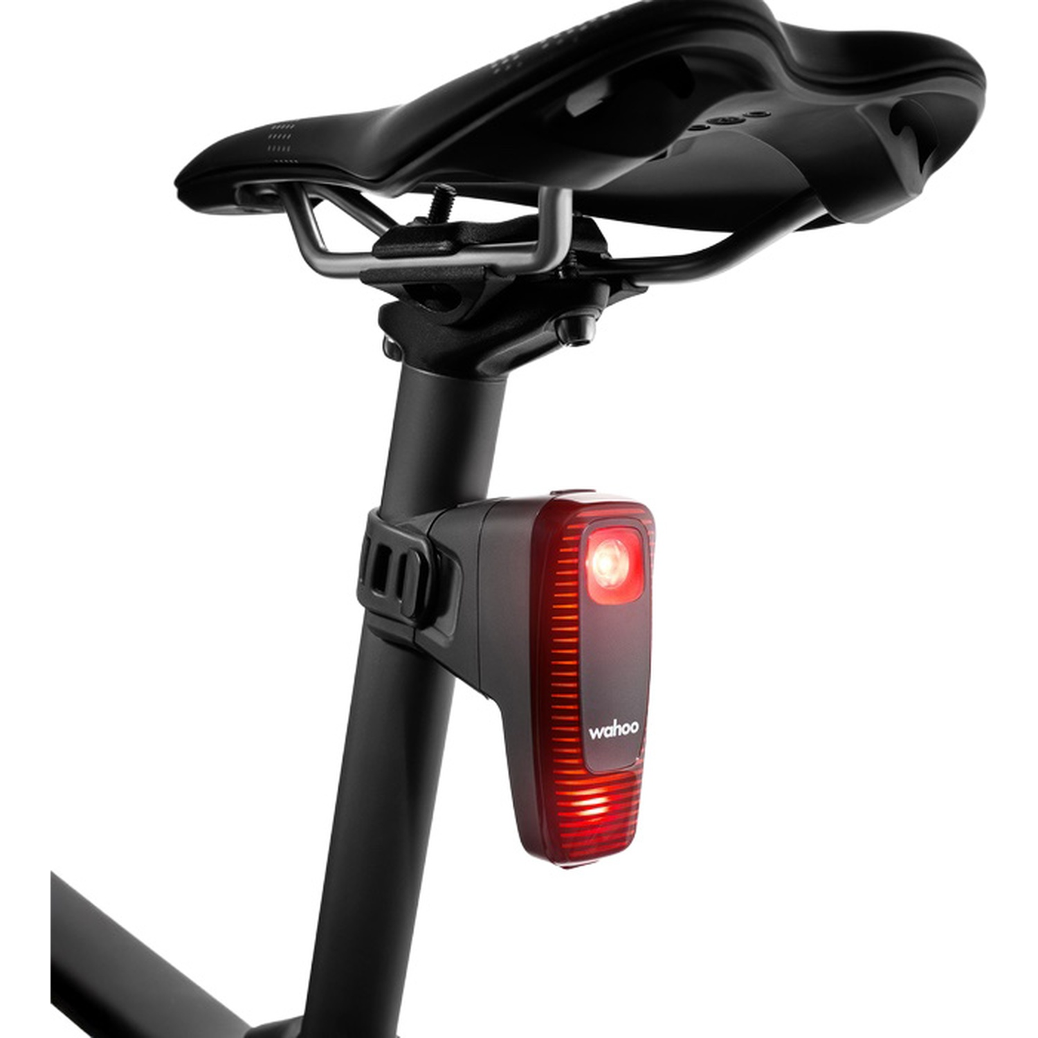 Feu arrière de vélo rouge attaché à une selle noire.