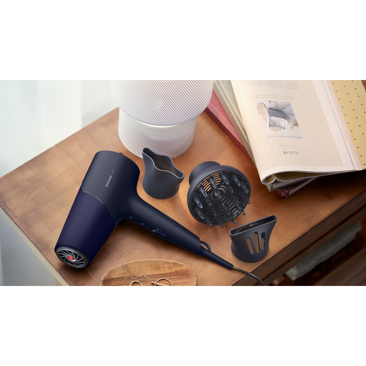 Dark blue hairdryer with attachments on a wooden table.
