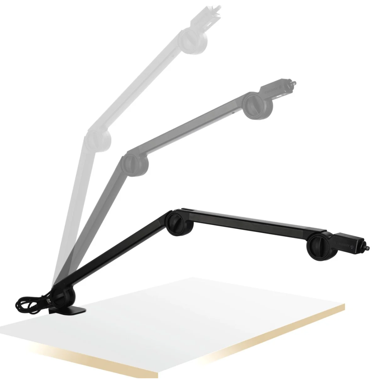 Een zwarte, verstelbare zwenkarm in drie posities op een wit bureau.