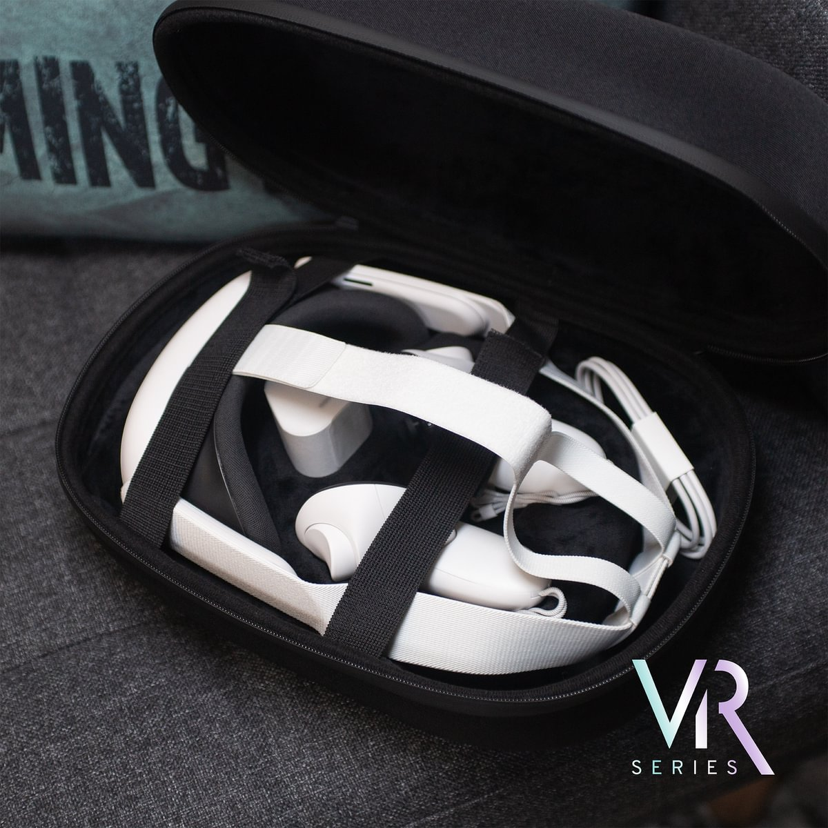 Ein VR-Headset und Controller in einem schwarzen Koffer auf einem grauen Stoff.