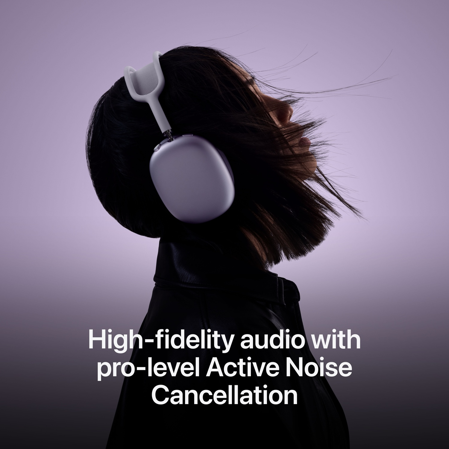 Woman wearing silver headphones, side profile, with hair blowing.