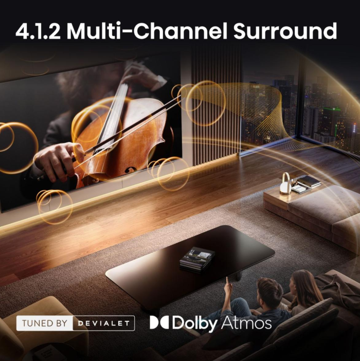 Ein Paar sitzt auf einem Sofa und blickt auf einen Fernseher, der einen Cellisten zeigt. Dolby Atmos.
