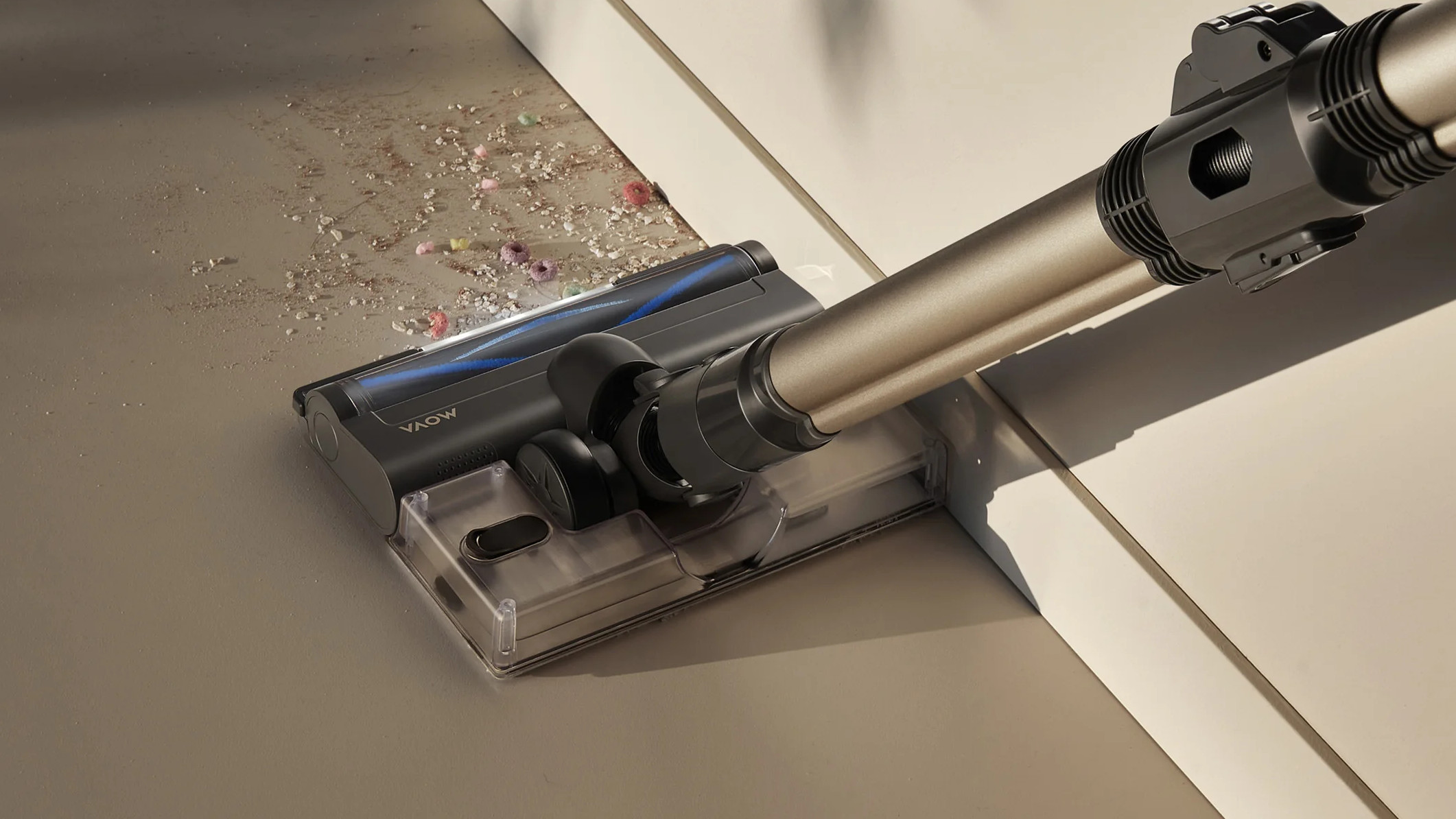 Głowica odkurzacza zasysa okruchy z jasnej podłogi.