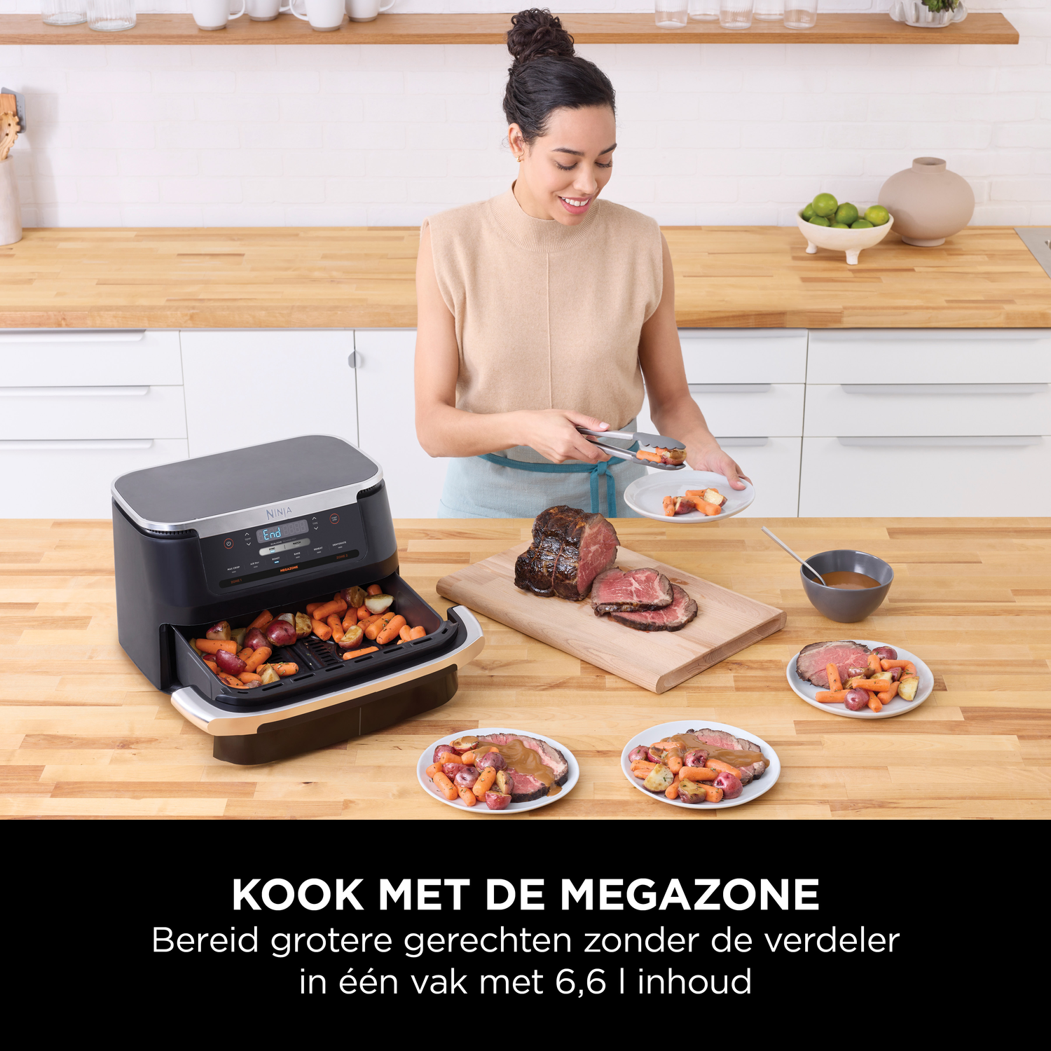 Een vrouw legt gebraden vlees en groenten uit een airfryer op een bord.
