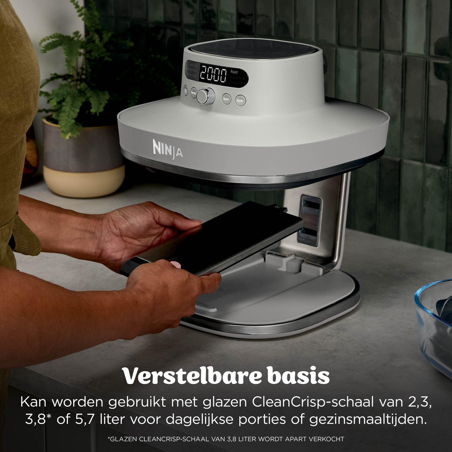 Een persoon plaatst een lade in een grijze Ninja airfryer basis unit.