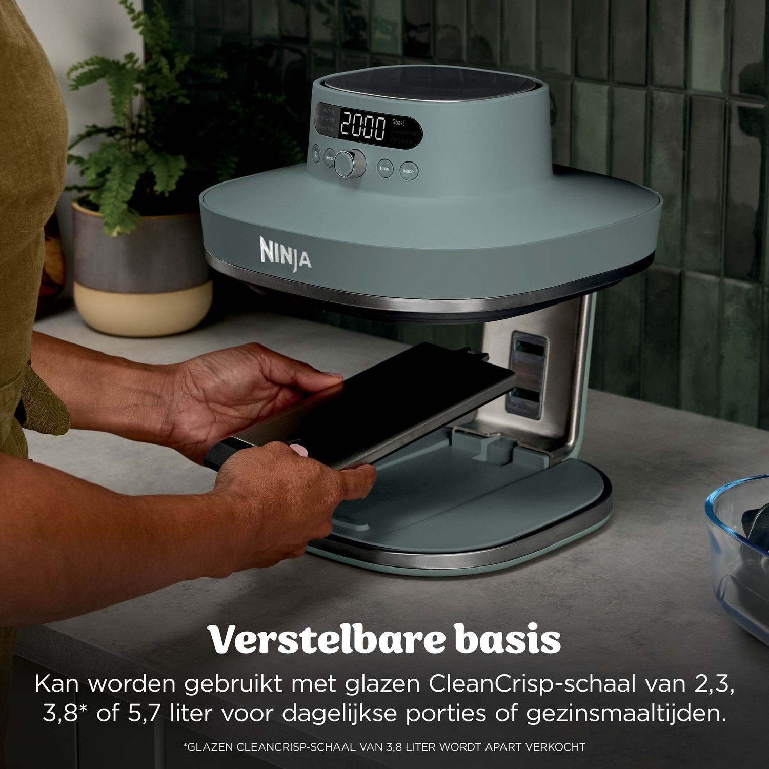 A person uses a blue Ninja air fryer with digital display and controls.