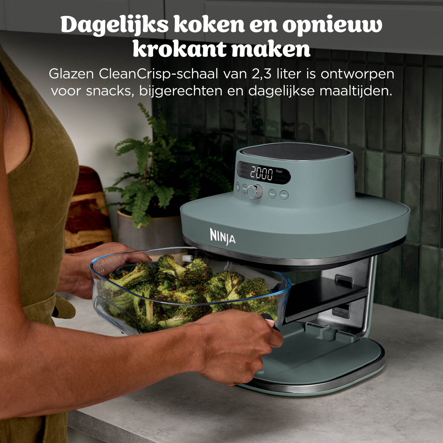 Person places broccoli in a Ninja air fryer oven.