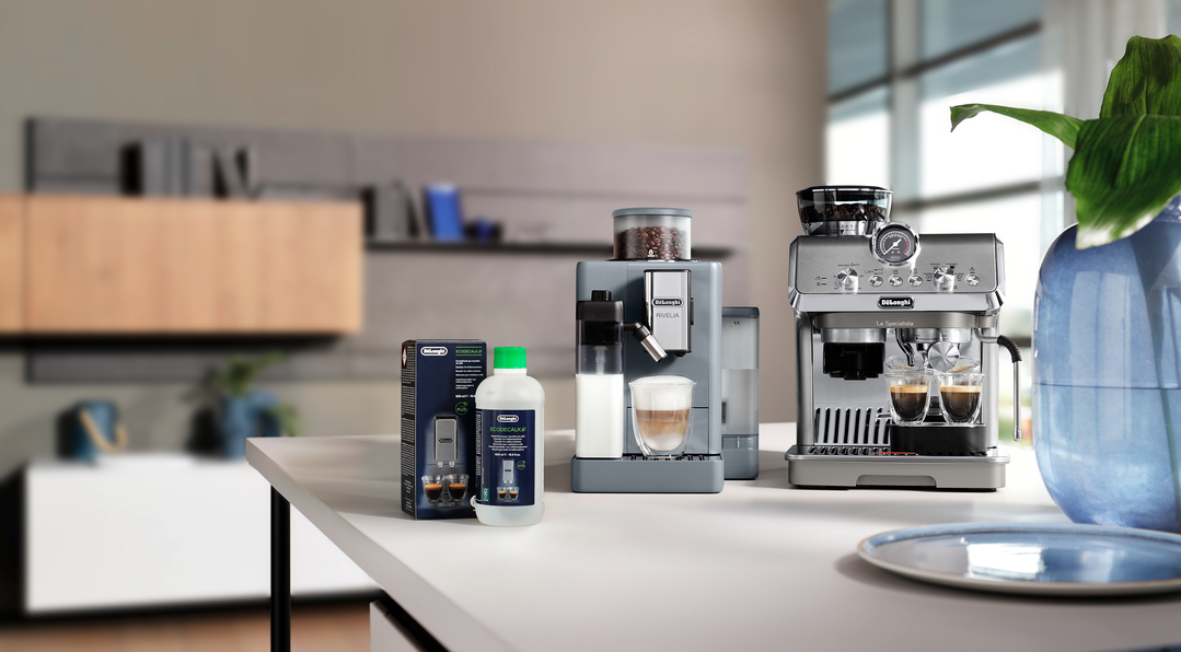 Zwei DeLonghi Espressomaschinen stehen auf einem Tisch mit Kaffeebohnen und Milch.