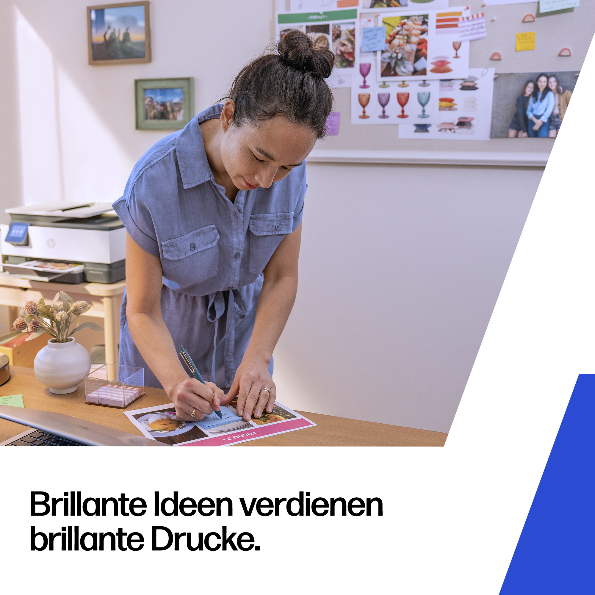 Eine Frau in einem blauen Kleid schreibt auf einem Ausdruck, ein Drucker steht daneben.