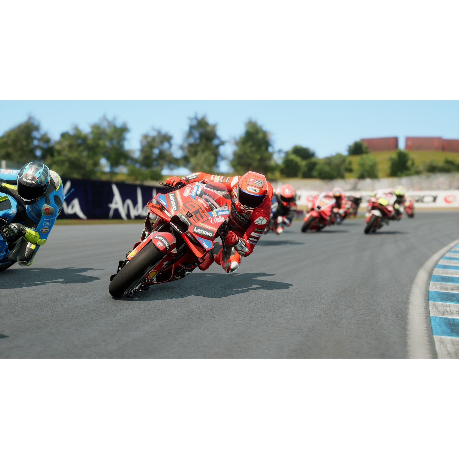 Motociclisti in tuta rossa e blu si piegano in curva su un circuito.
