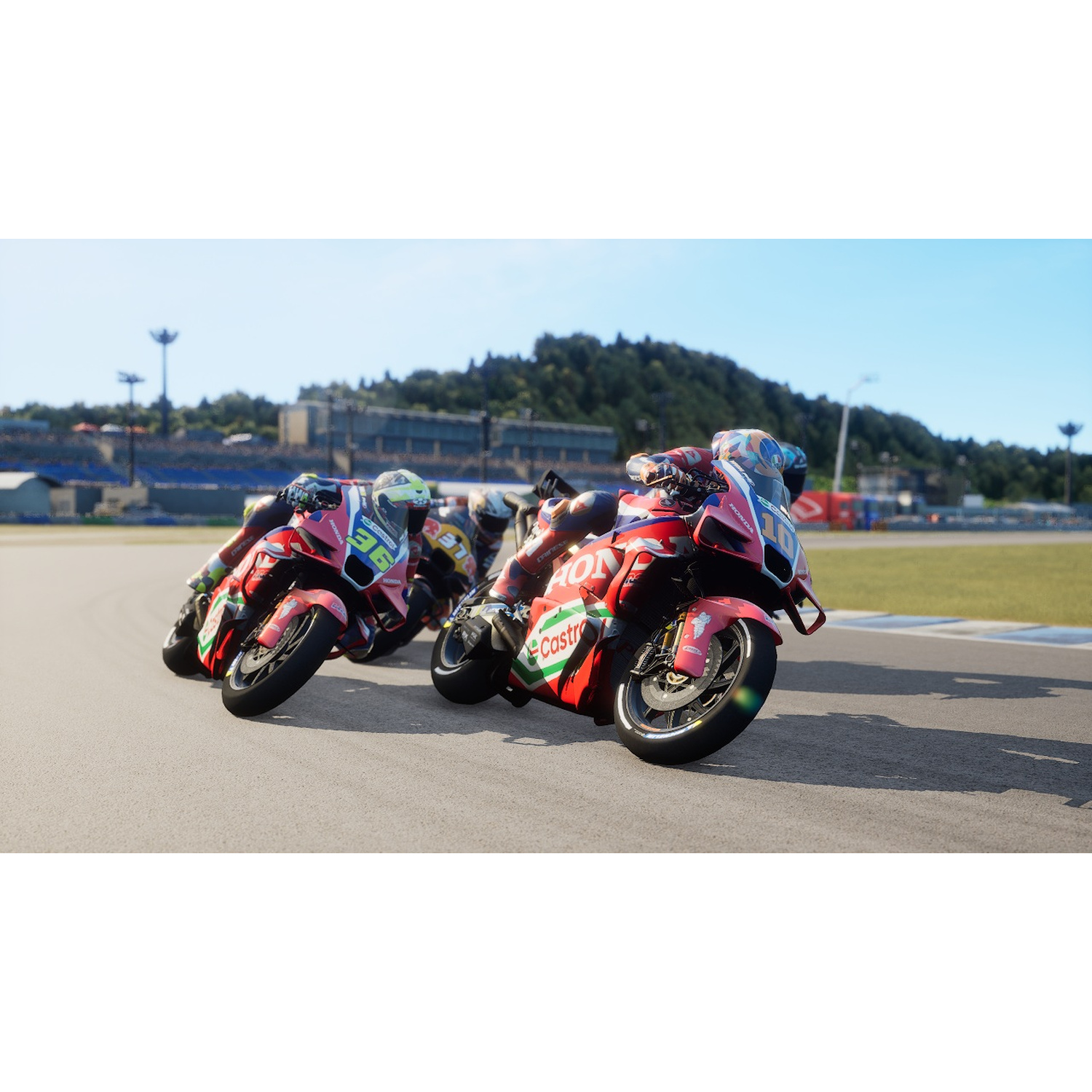 Motociclisti su moto rosse su una pista da corsa sotto un cielo blu.