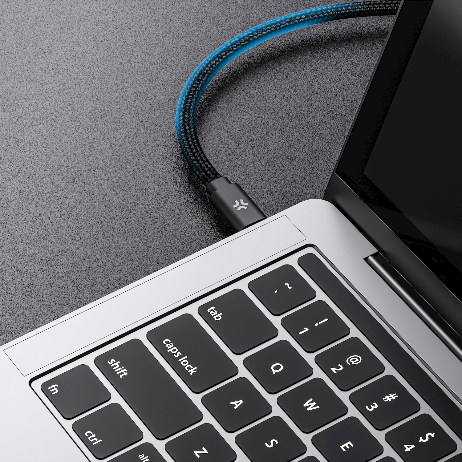 Un cavo USB-C nero con accenti blu si collega a un laptop.