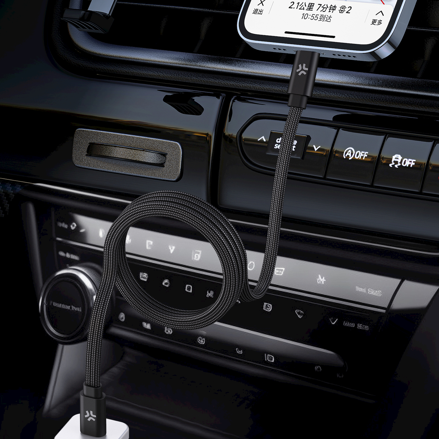 Un cavo nero carica un telefono in un'auto, situato sul cruscotto.