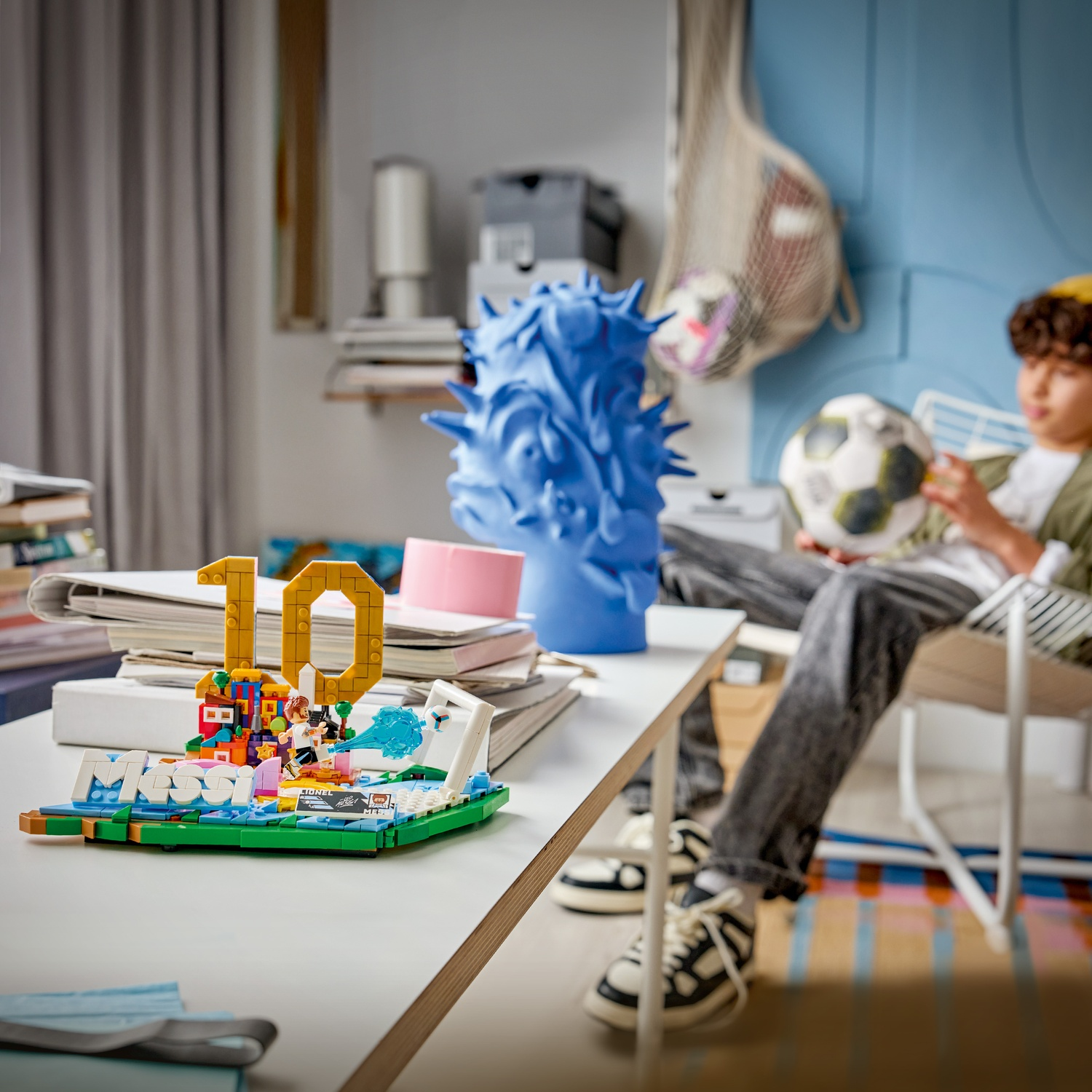 Espositore LEGO con 10, testo Messi, calciatori e porta. Ragazzo con pallone.