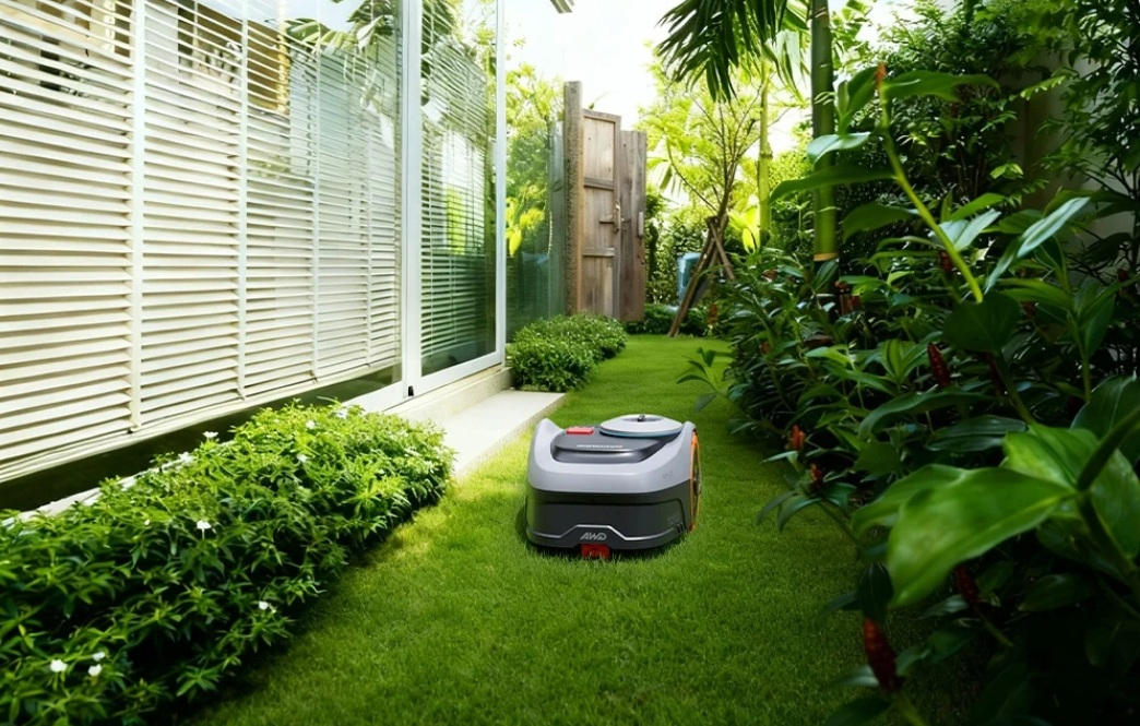Robot koszący stoi na idealnie przystrzyżonym trawniku w bujnym ogrodzie.