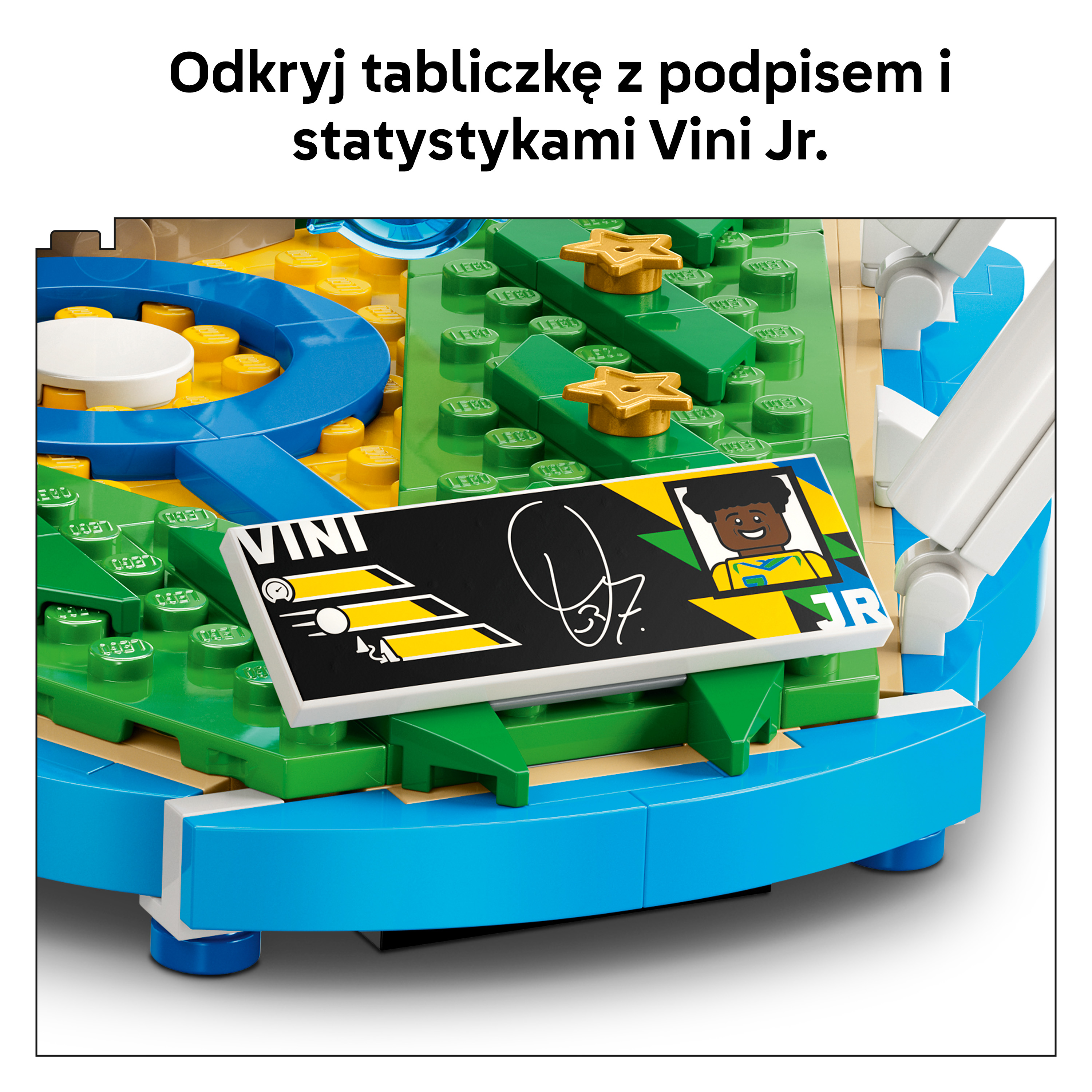 Zbliżenie na budowlę z klocków Lego z niebieską podstawą, zielonymi i żółtymi płytkami oraz tabliczką.