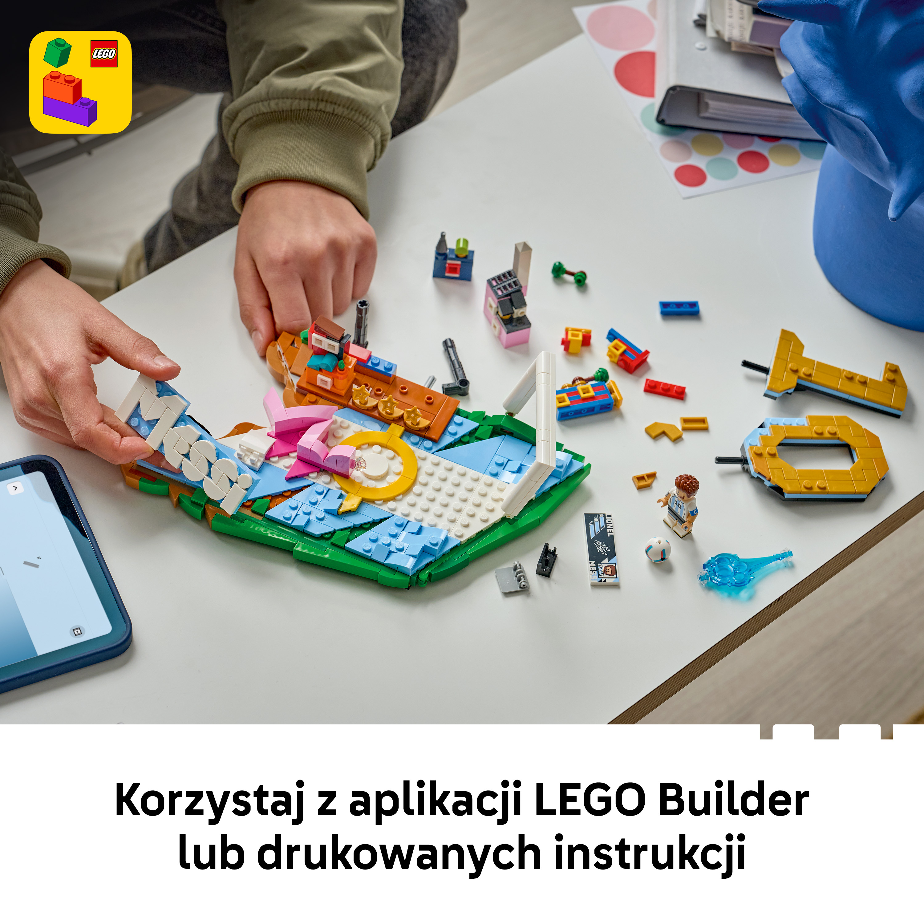 Ręce budują z kolorowych klocków LEGO. Tablet pokazuje instrukcje.