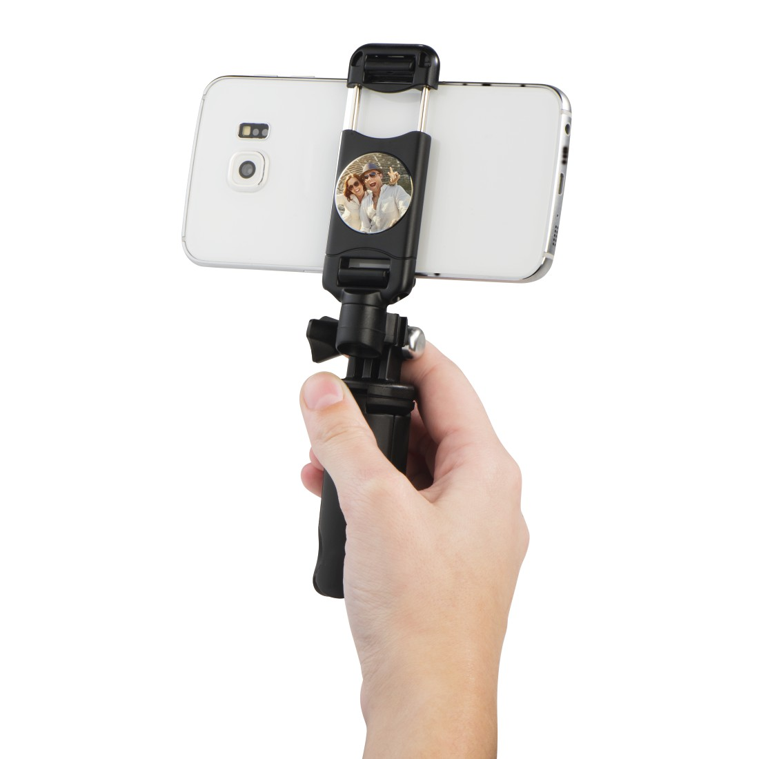 Bir el, üzerinde çift resmi olan bir selfie çubuğunda akıllı telefon tutuyor.