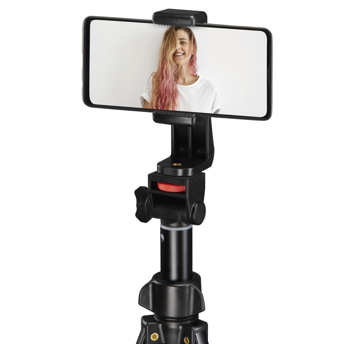 Bir tripod üzerindeki akıllı telefon, pembe saçlı gülen bir kadını gösteriyor.