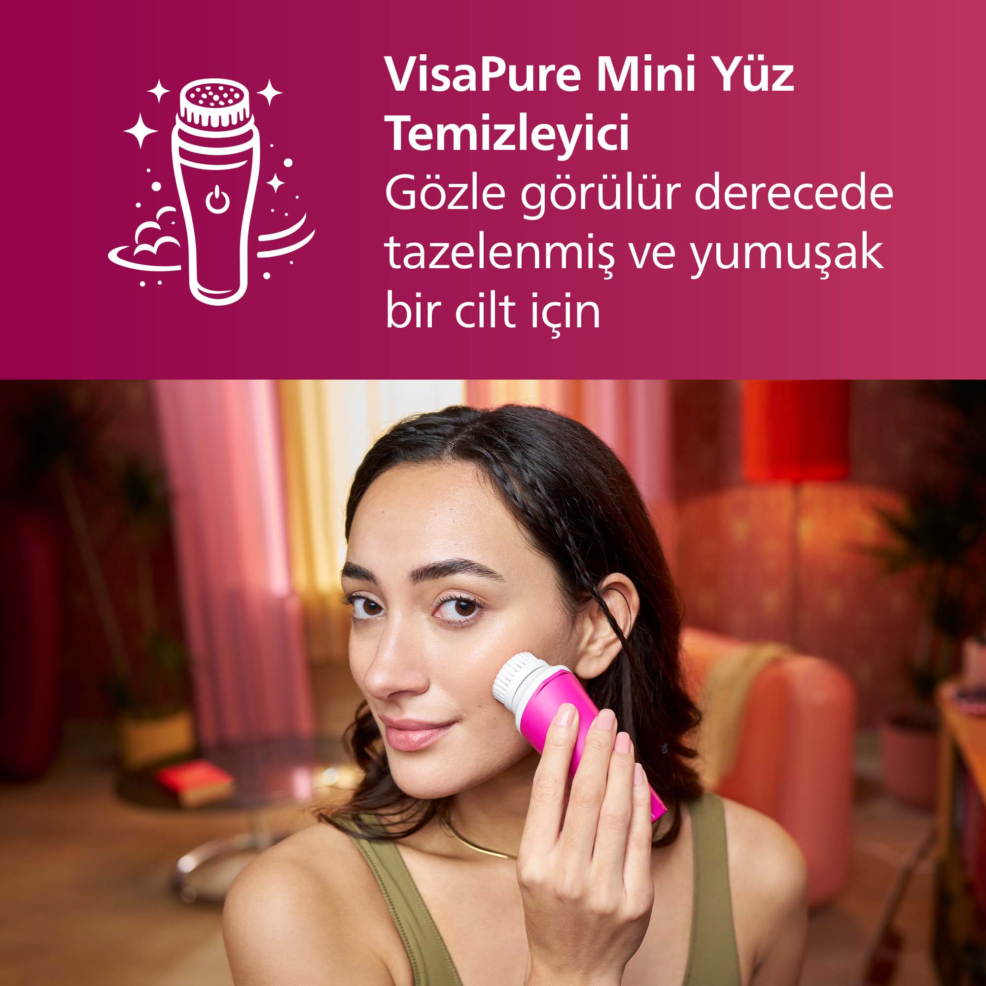 Kadın, bulanık arka plan önünde pembe bir yüz temizleme cihazı kullanıyor.
