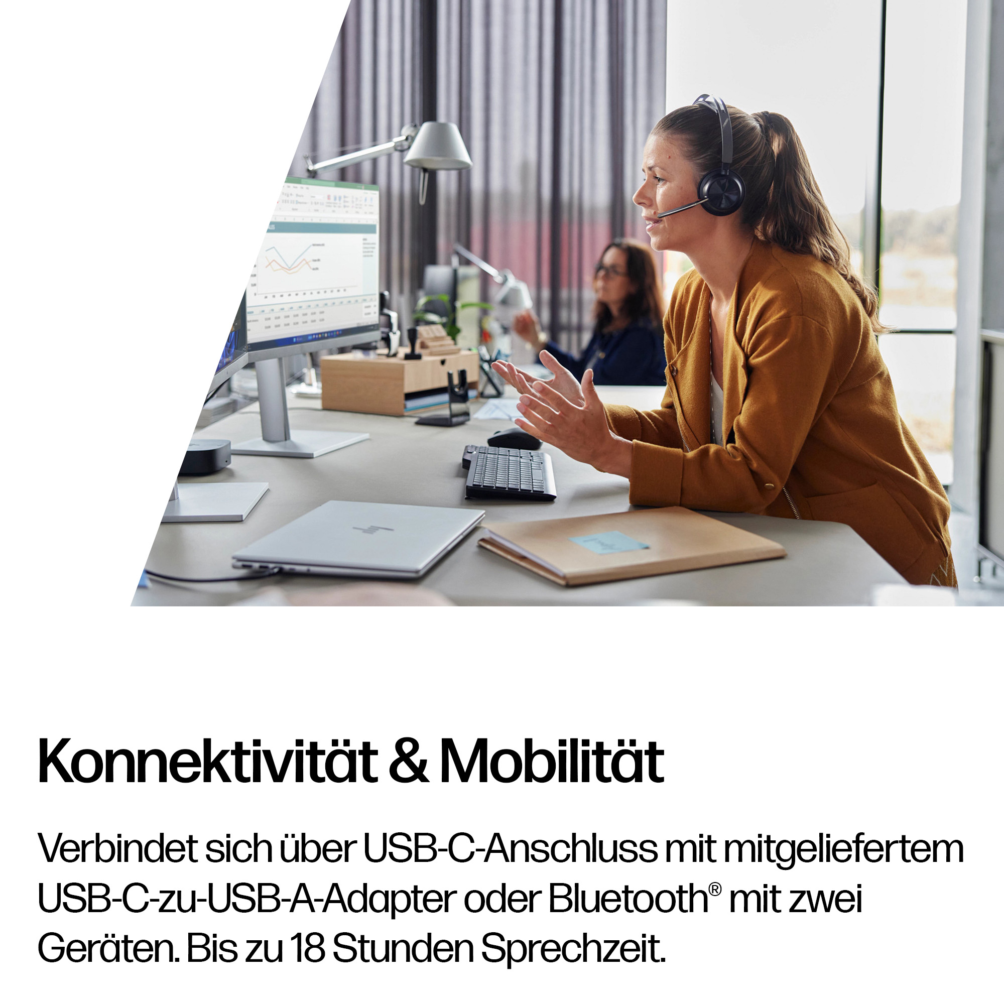 Frau mit Headset am Schreibtisch, mit Laptop und Monitor.