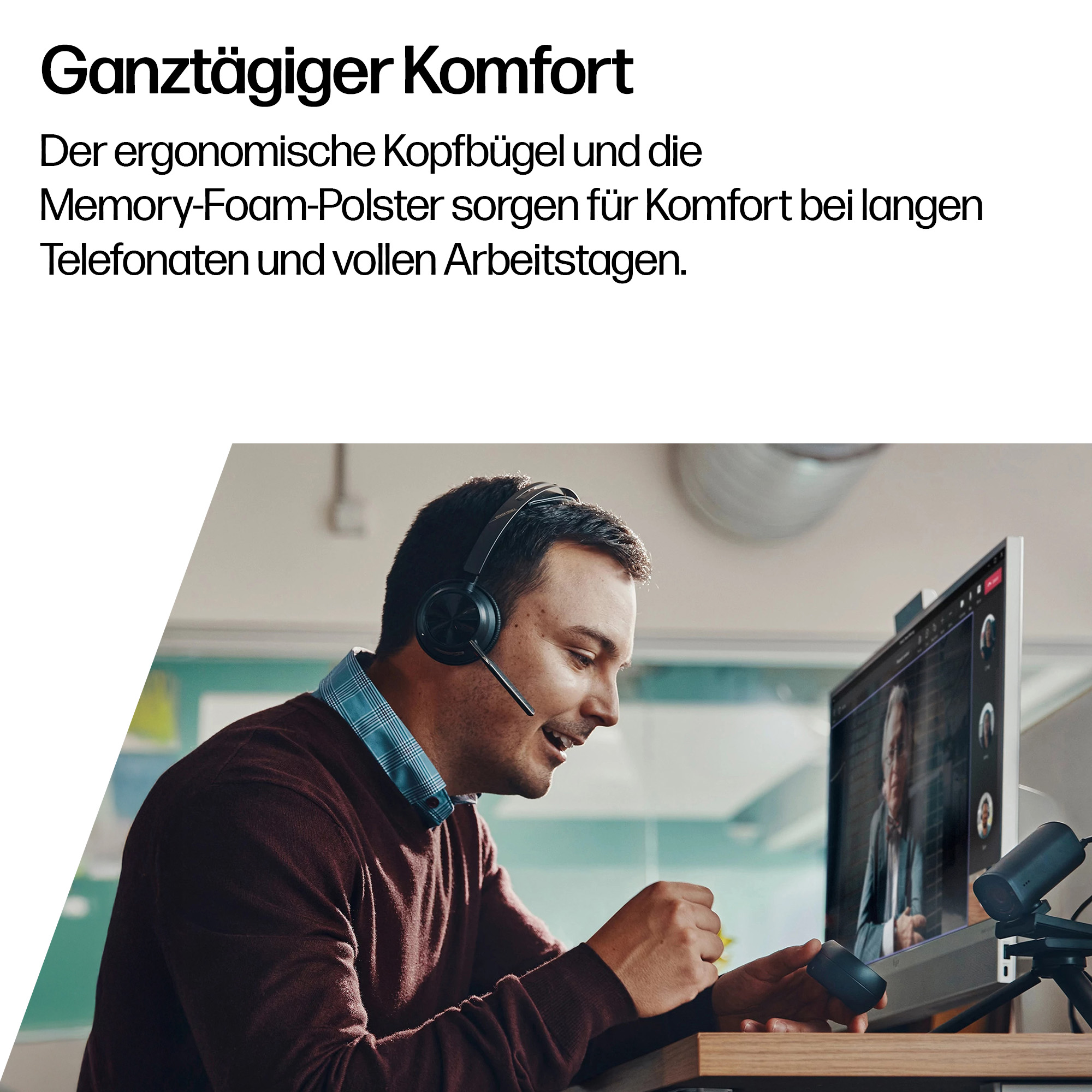 Mann mit Headset im Videocall, sitzt am Schreibtisch vor einem Monitor.